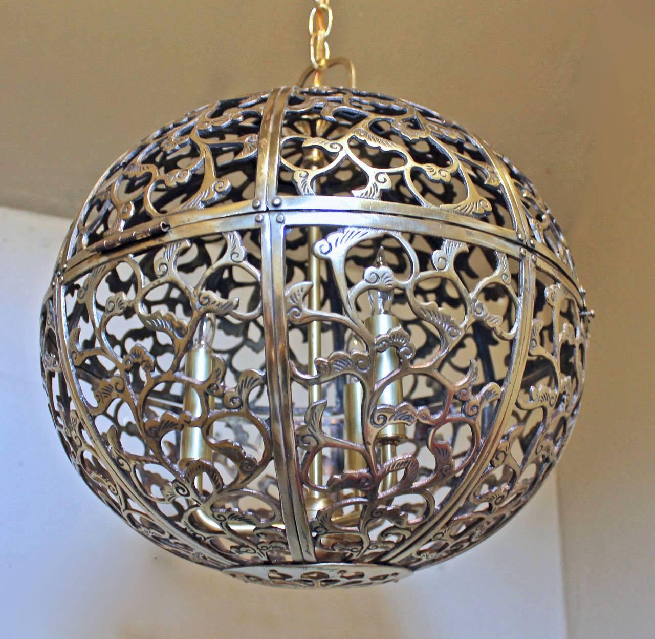 A large high quality heavy pierced brass pendant light with Asian scrollwork pattern. Newly wired with new triple cluster light sockets and solid brass fittings. Includes chain and ceiling cap, ceiling drop can be adjusted as needed. Uses 3- 40 watt