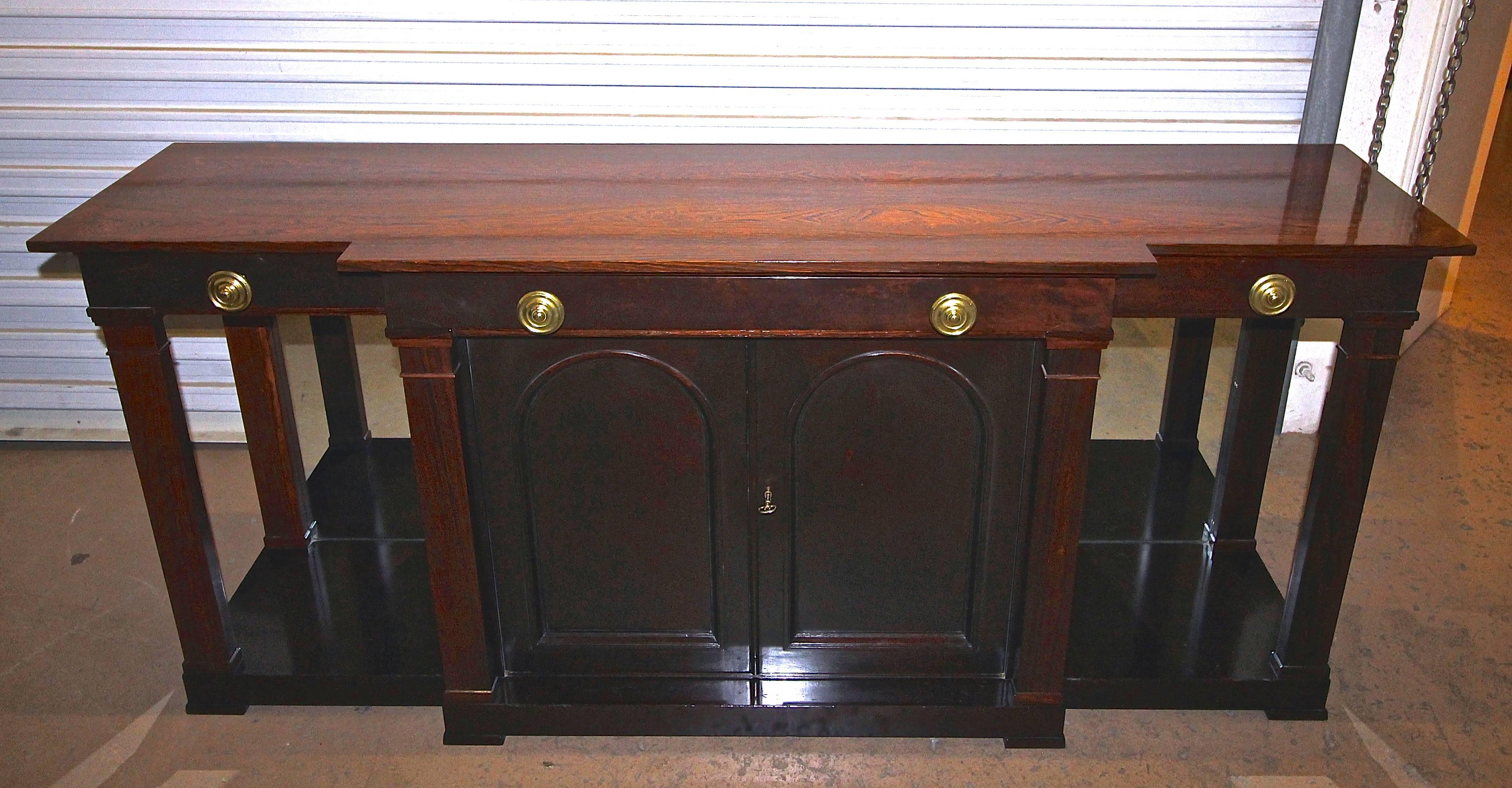 An exquisite and rare Dunbar sideboard or buffet designed by Edward Wormley (1907-1995) in rosewood and mahogany. This piece is reminiscent of the early designs of Wormley for Dunbar with a distinctive English Regency aesthetic. This breakfront has