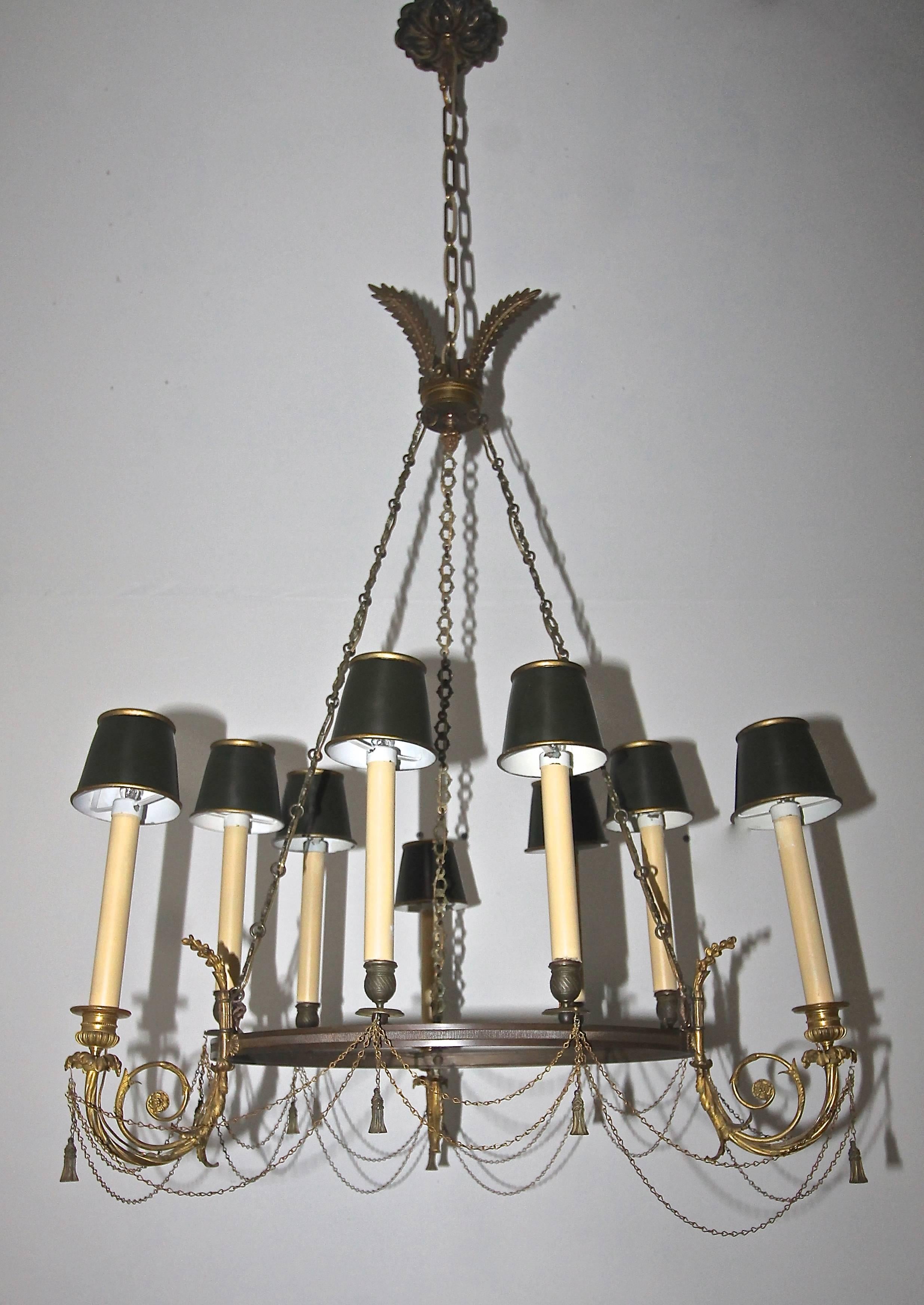 Beautifully detailed Empire style gilt bronze nine-light chandelier. Delicate and open construction with an atypical layout of candle cups resemble Baltic, Russian and Swedish of the time period. Finely detailed draped swags of chains and tassels