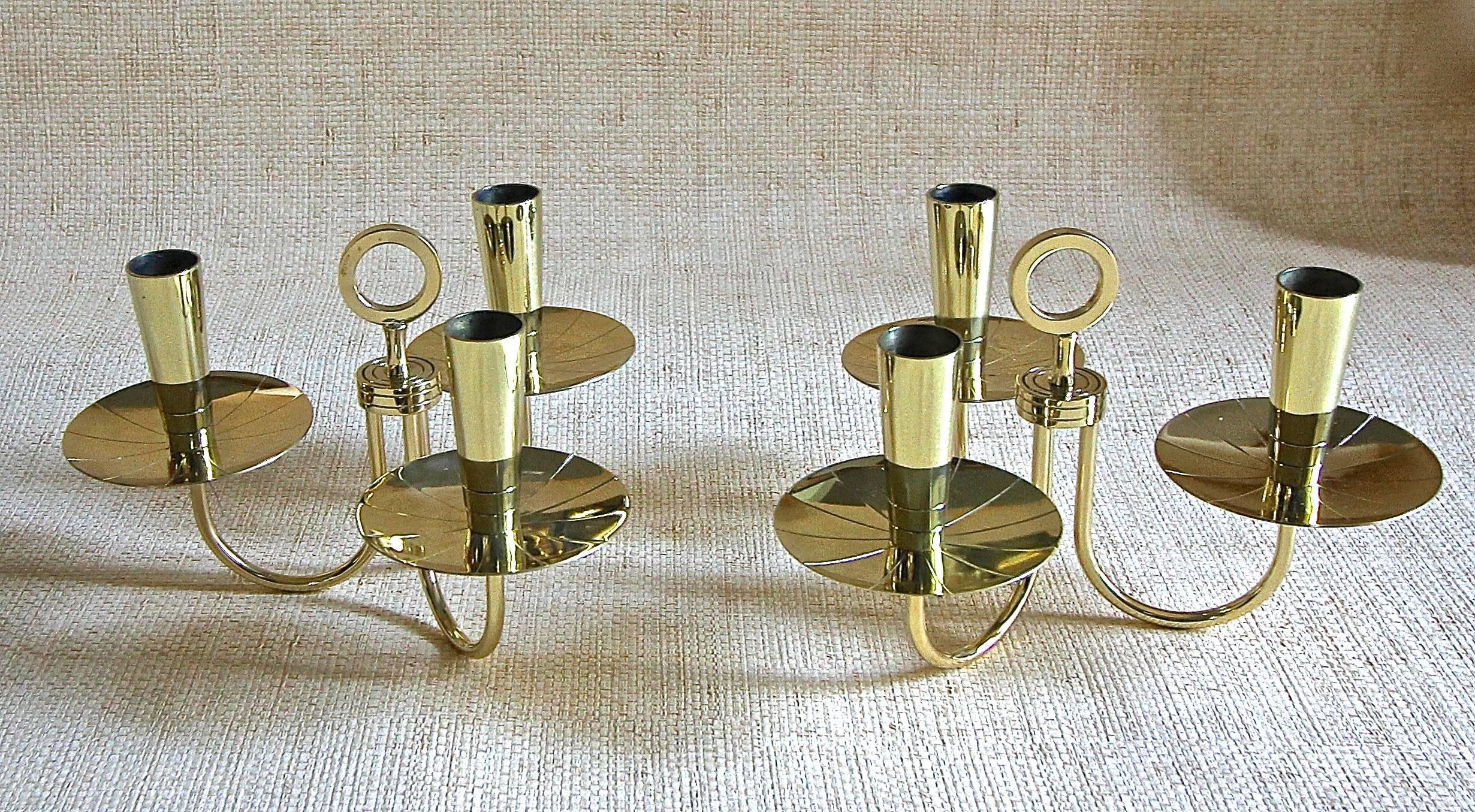 A rare pair of brass three-arm candelabras designed by Tommi Parzinger for Dorlyn Silversmiths. Professionally polished and lacquered. 

Each element of the Dorlyn accessories was handcrafted from sheet brass in New York. This pair has been more