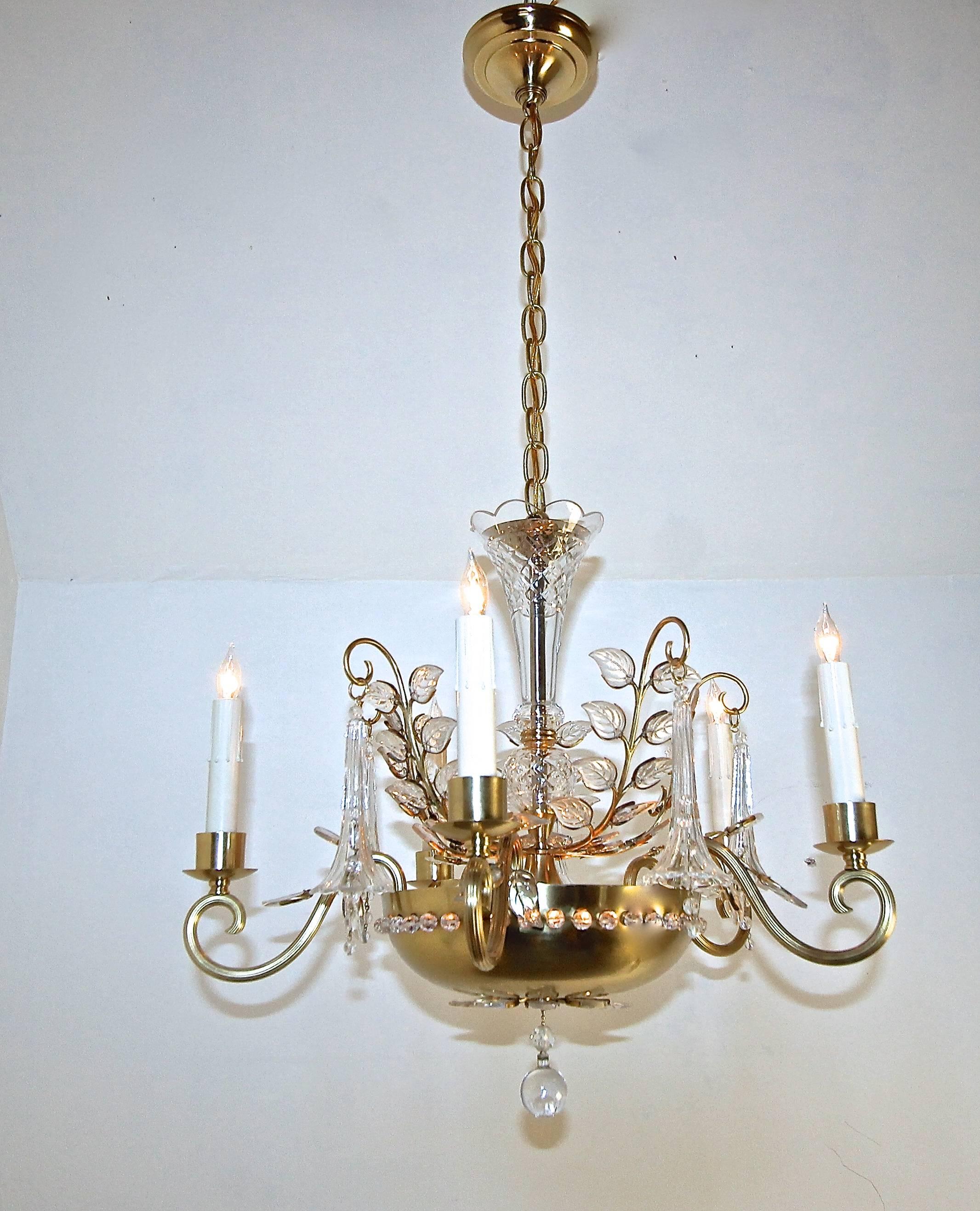 Dish form chandelier in the style of Maison Baguès. Chandelier is illuminated by five candle arms as well as three interior lights that illuminate the pierced brass dish and crystal elements. Center column is surrounded by crystal leaves with