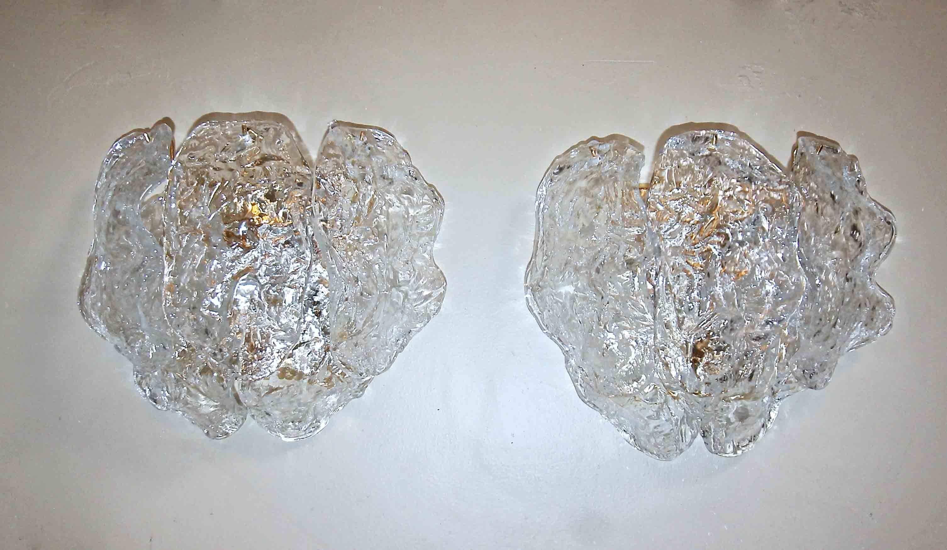 Pair of Italian Murano handblown glass wall sconces with sculpted clear textured panels on brass-plated backplates. Each fixture uses 2 - 40 watt max candelabra base bulbs. Newly wired.