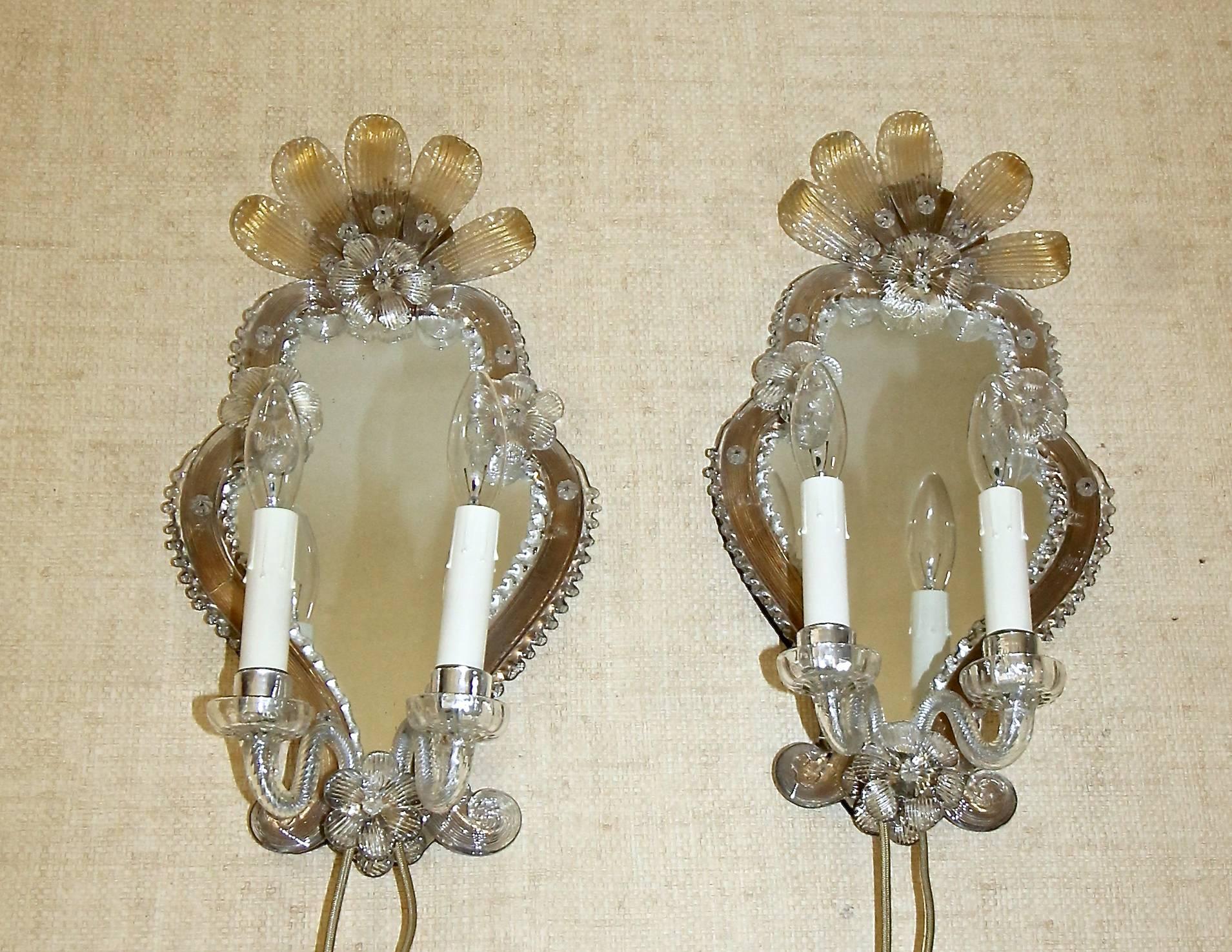 Pair of Venetian two-light mirrored sconces with clear and gold flowers and applied clear glass scroll decoration. Each sconce uses 2-40 watt max candelabra base bulbs. Newly wired.