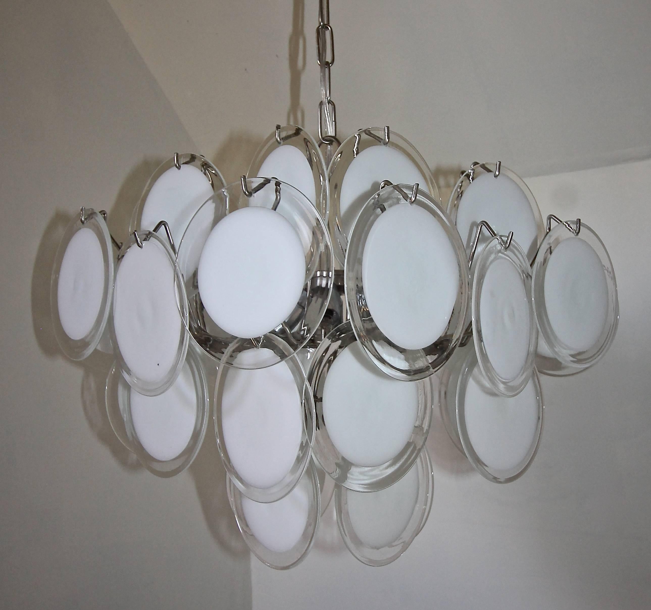 Clear and white disc Murano Italian glass four-light chandelier. Steel frame. Uses 4 - 40 watt max candelabra base bulbs, newly wired. The diagonal length is 24