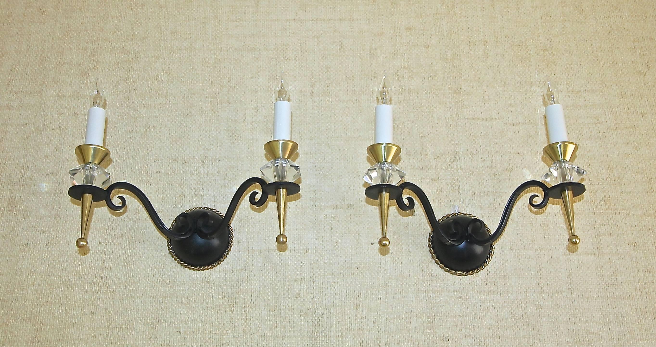 Pair of French two-arm gilt and black patinated wall sconces, with cut crystal accents and brass fittings. Attributed to Jules Leleu.