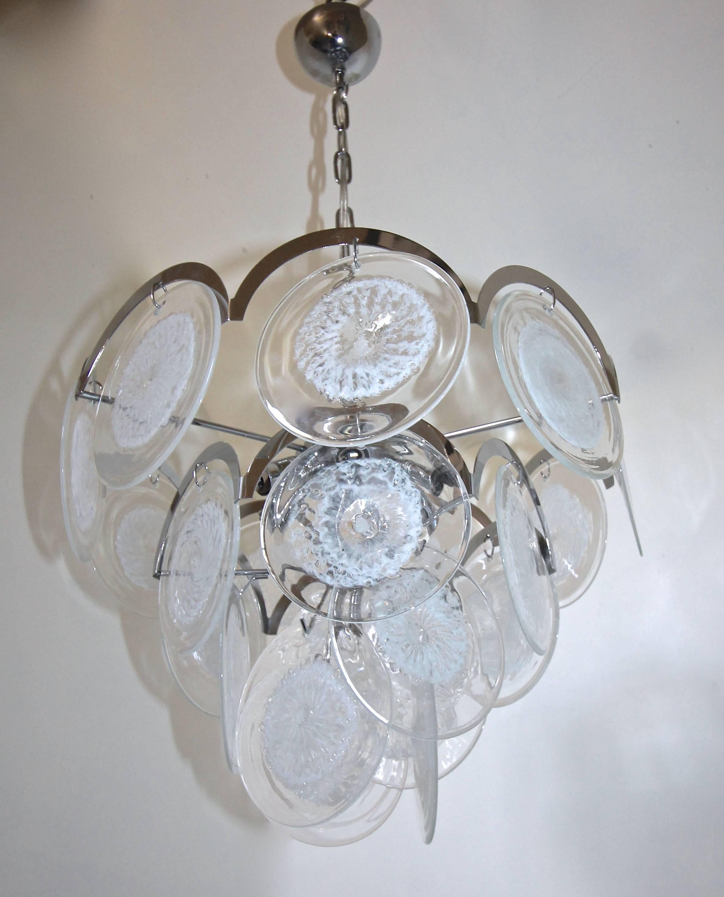 Italian Vistosi style seven-light chandelier with clear and white swirled blown glass discs suspended from a chrome-plated metal frame. Fixture is newly wired and uses seven 40-watt max candelabra base bulbs. Chandelier size 18" dial x 16"