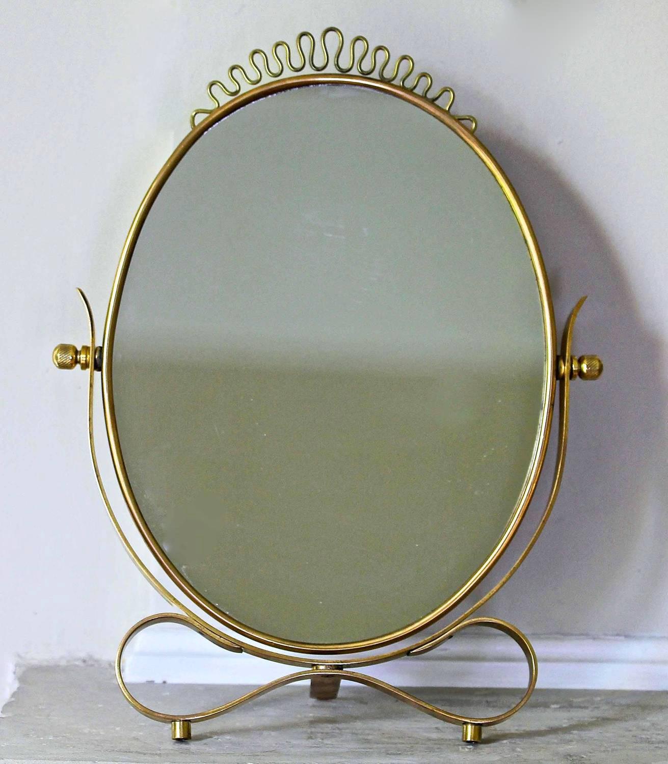 Very attractive Italian brass vanity table mirror, in the style of Gio Ponti. Solid brass construction with wood backing.