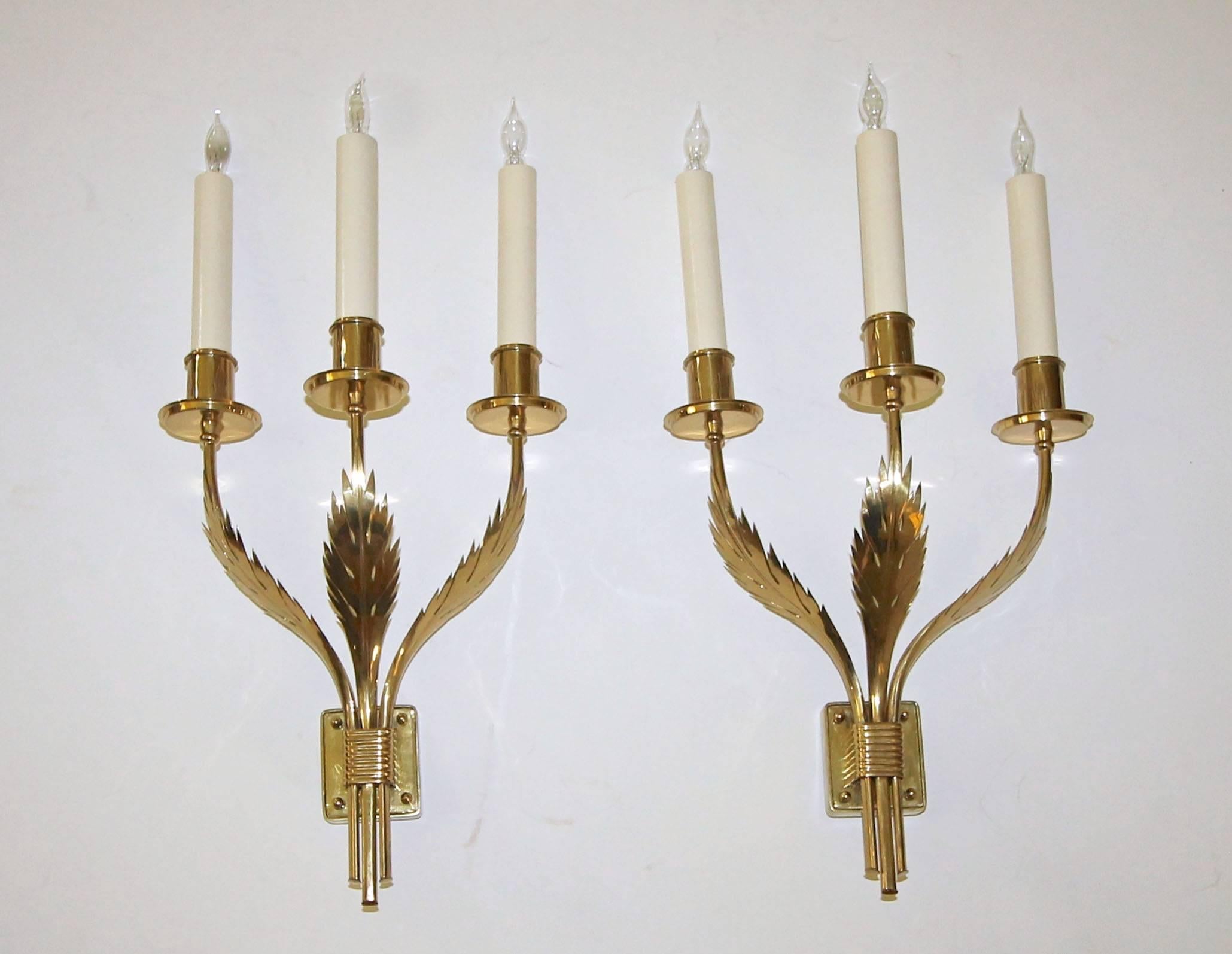 Pair of extremely rare Tommi Parzinger designed wall sconces for Parzinger Originals, handcrafted by Felix Balbo. Solid brass construction with beautiful acanthus leaf motif that is repeated on each candle cup. Newly wired and retaining the original