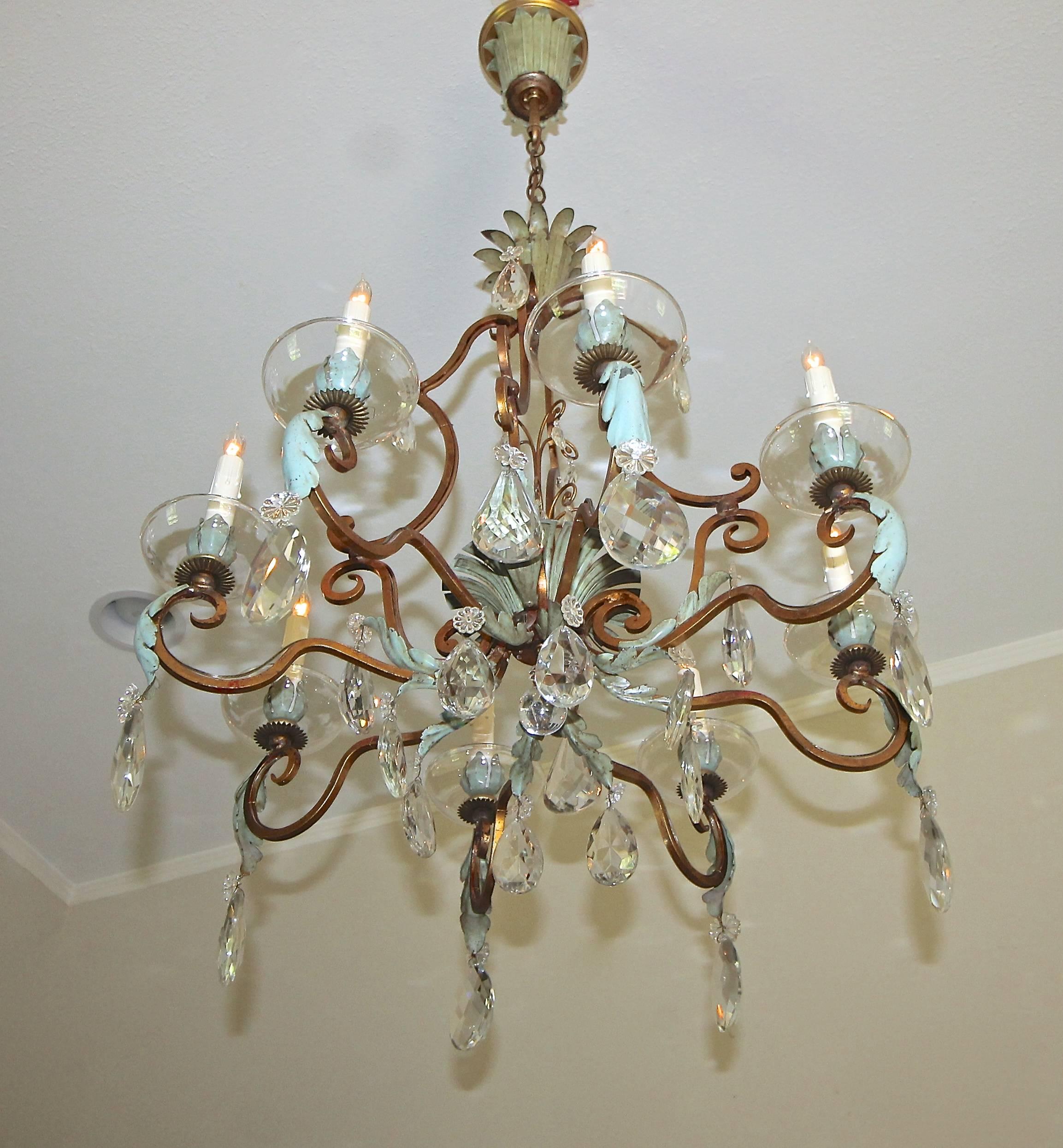 Outstanding French 1920s gilt iron and cut crystal chandelier with painted tole details. Beautiful cage form with 8 arms and scroll work in the French Art Deco style. Wonderful overall detailing and patina in the original finish. Chandelier uses