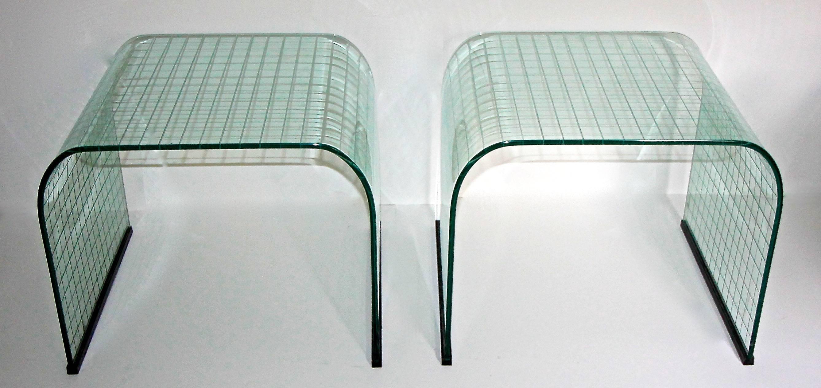 A beautiful pair of early production tempered glass side or end tables in a fluid 