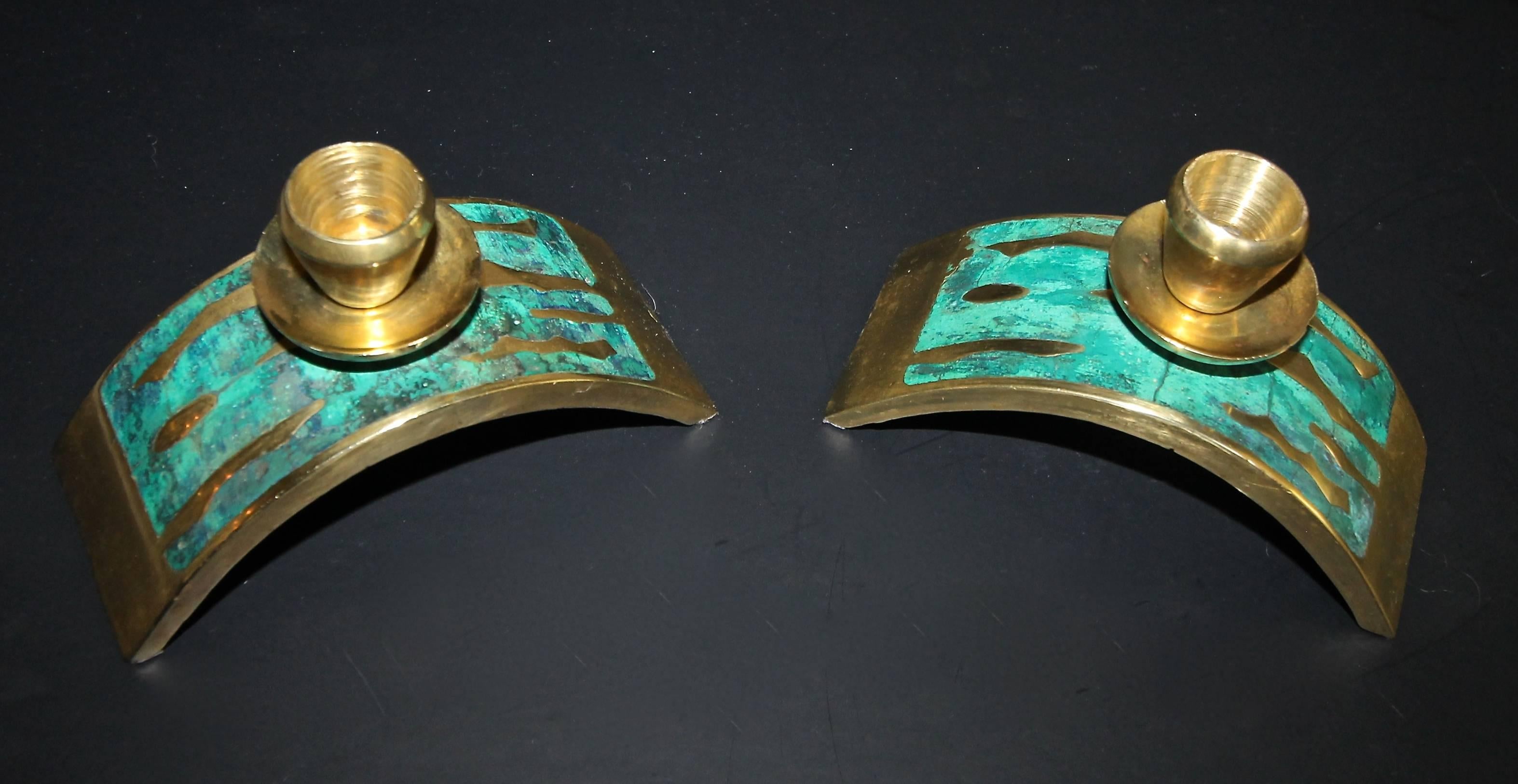 A rare pair of Pepe Mendoza modernist arched candlesticks or candle holders. Heavy solid cast brass construction with inset turquoise colored composite stone accents. Lightly impressed oval stamp to underside of both pieces.

Size of each