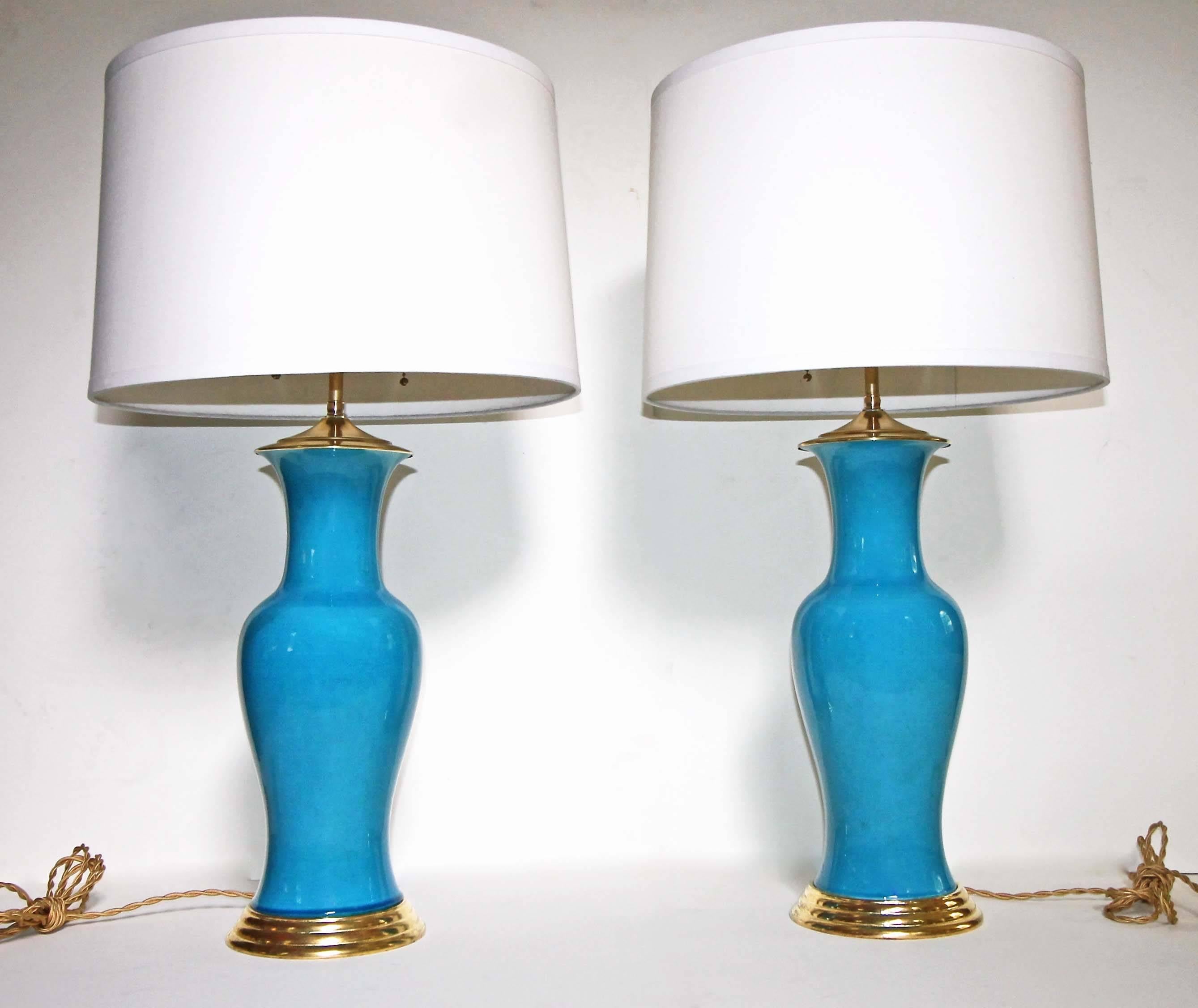Pair of vibrant turquoise blue ceramic table lamps on 23-karat water gilt turned wood bases. Mid-Century hand thrown and glazed Japanese vases converted to lamps. Newly wired including new on/off double clusters, brass fittings and adjustable shade