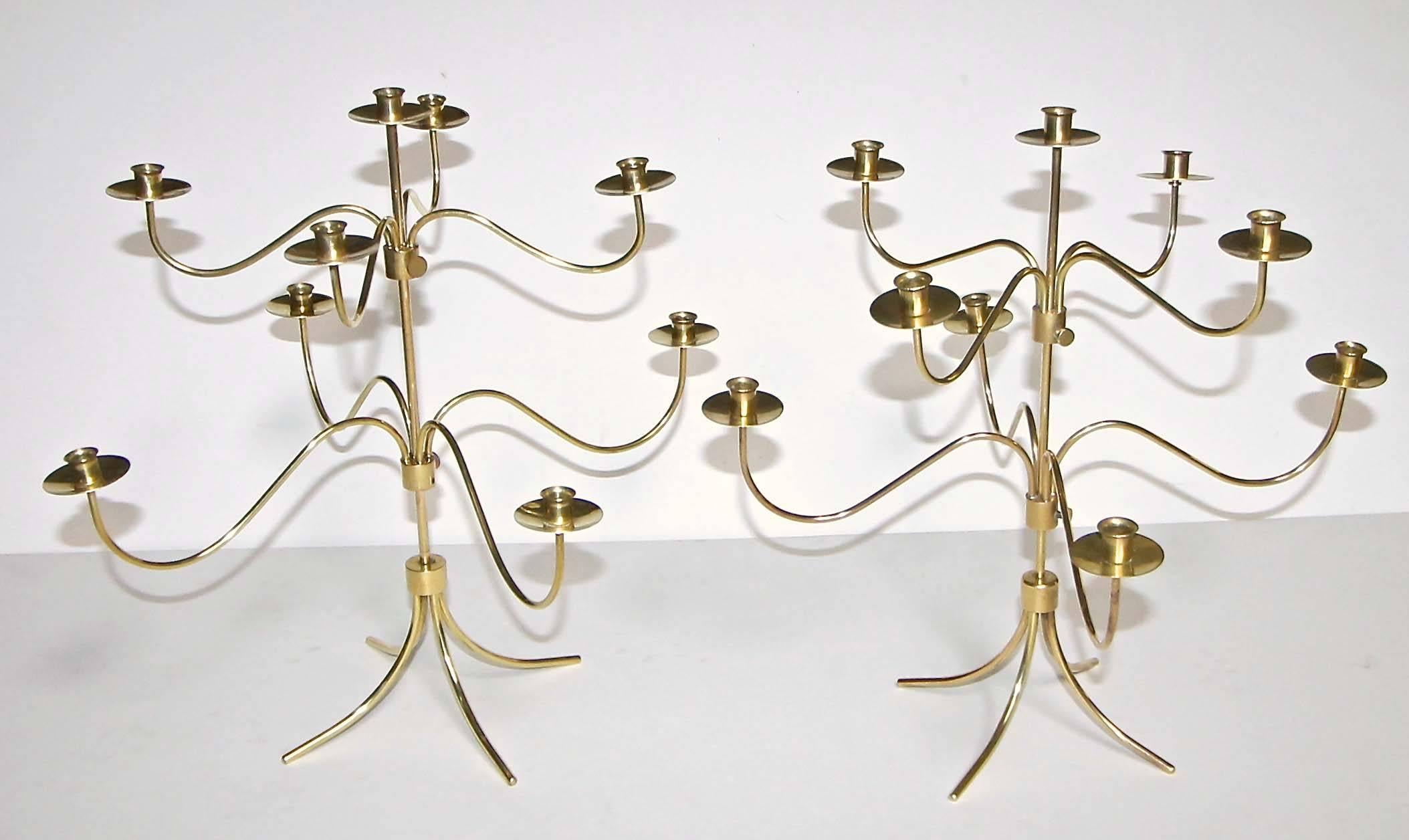 A pair of delicately handcrafted Mid-Century nine-arm brass Swedish candelabra or candleholders designed by Josef Frank for Svenskt Tenn. A thumb screw adjusts the height of the two levels. One candelabra is stamped "Made In Sweden".