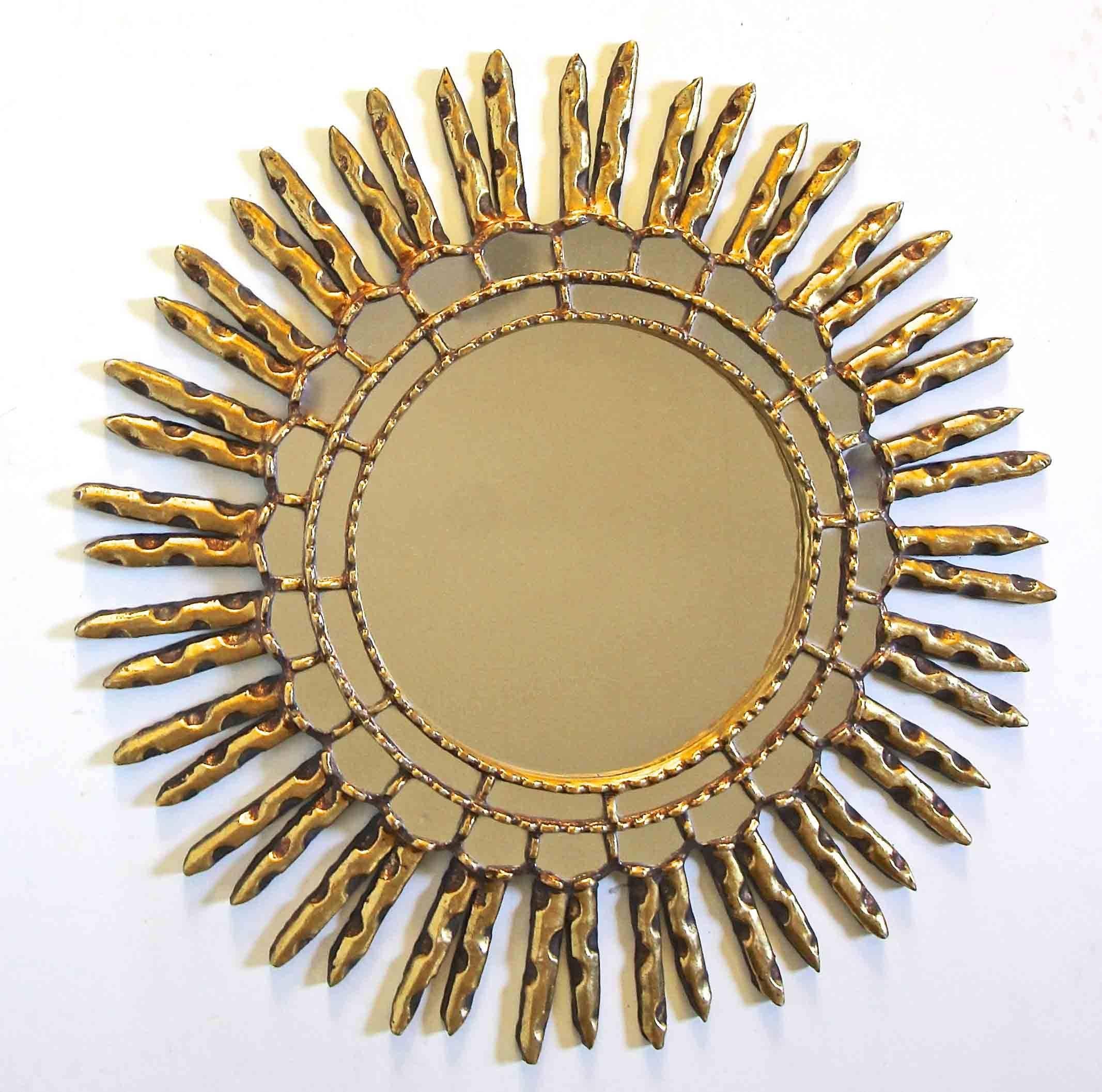 Hand-carved round giltwood sunburst wall mirror with two rows of inset small mirrors and carved wood and gilt detailing.