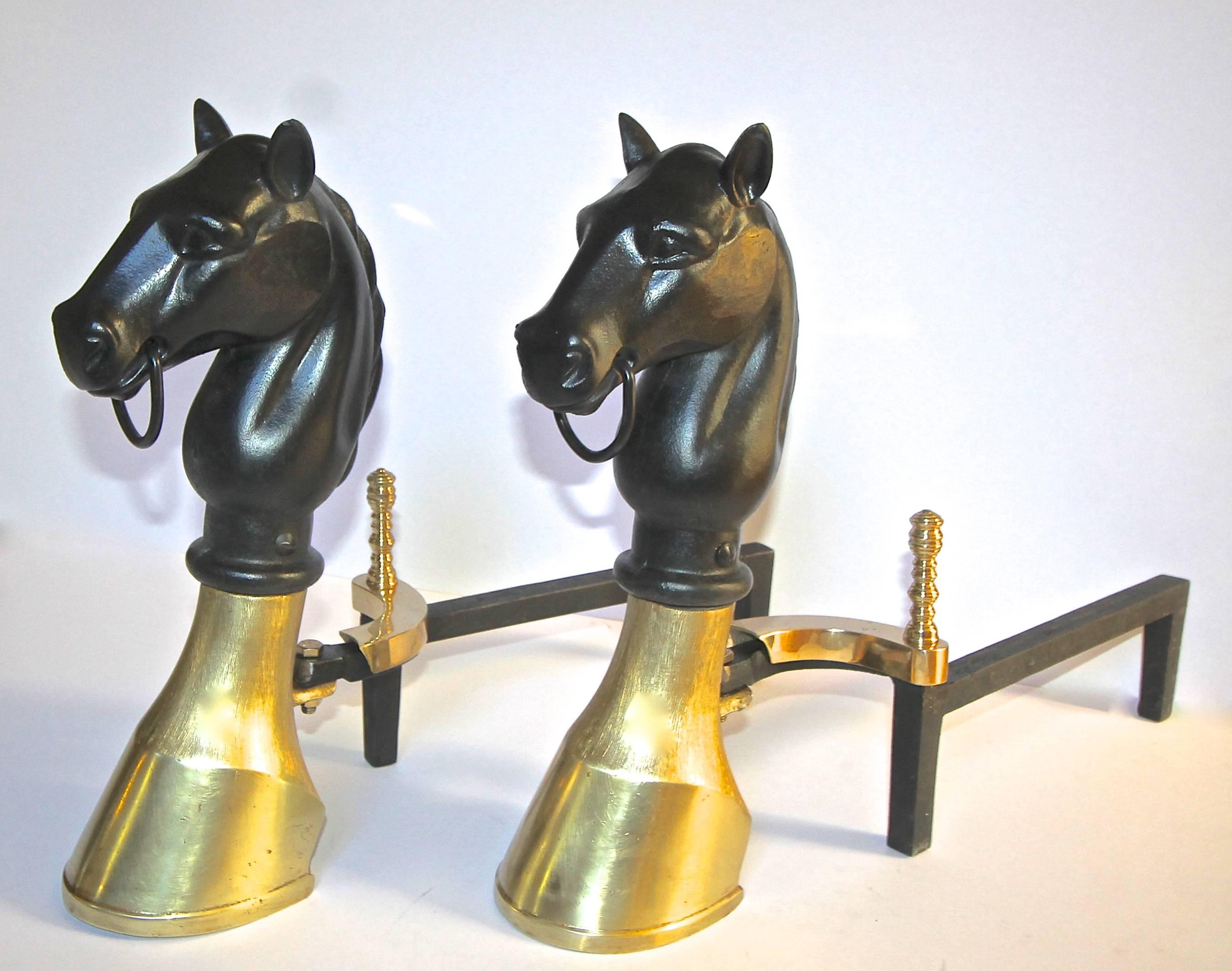 A very handsome pair of brass and cast iron andirons with a horse head and hoof motif.
