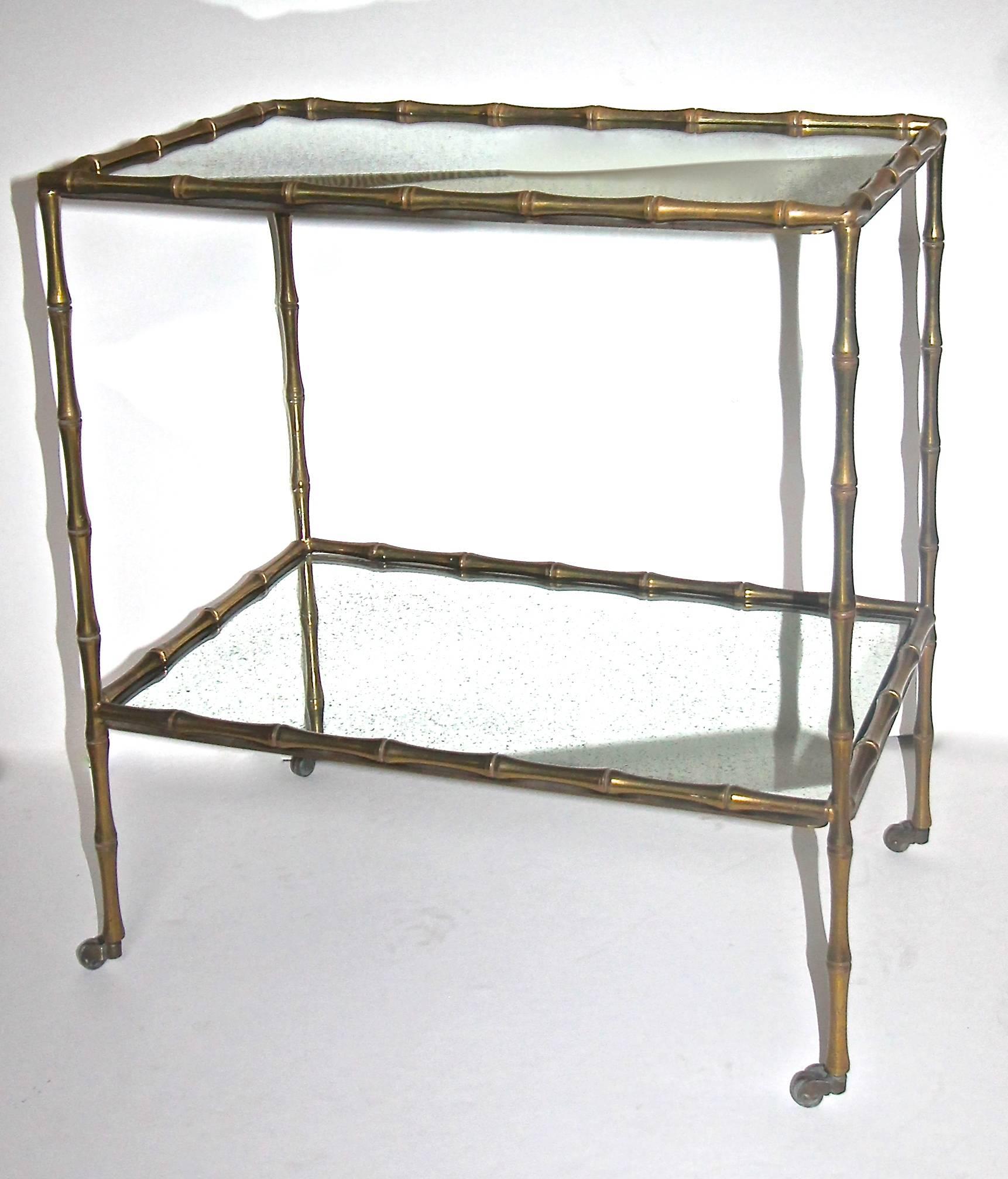 Beautiful bronze or brass faux bamboo side or end table by Maison Bagues. Table rests on four brass casters and could also be used as a bar cart or drinks table. Original inset mirrored glass tops with rich antiqued patina to mirrored backs.