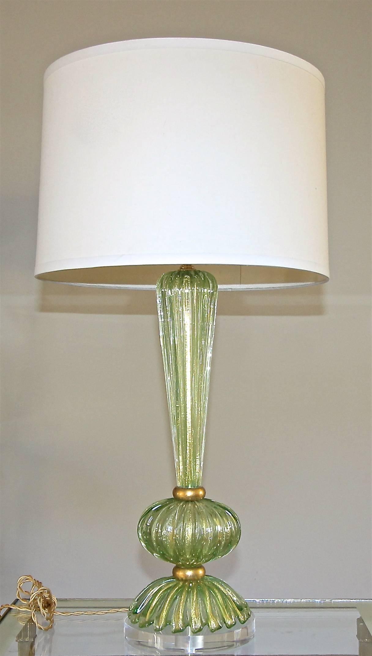 A single Italian Murano handblown glass lamp of cased green with gold inclusions. Ribbed baluster form glass in three parts separated by giltwood spacers. Newly wired with brass fittings and new full range dimmer socket, French style rayon covered