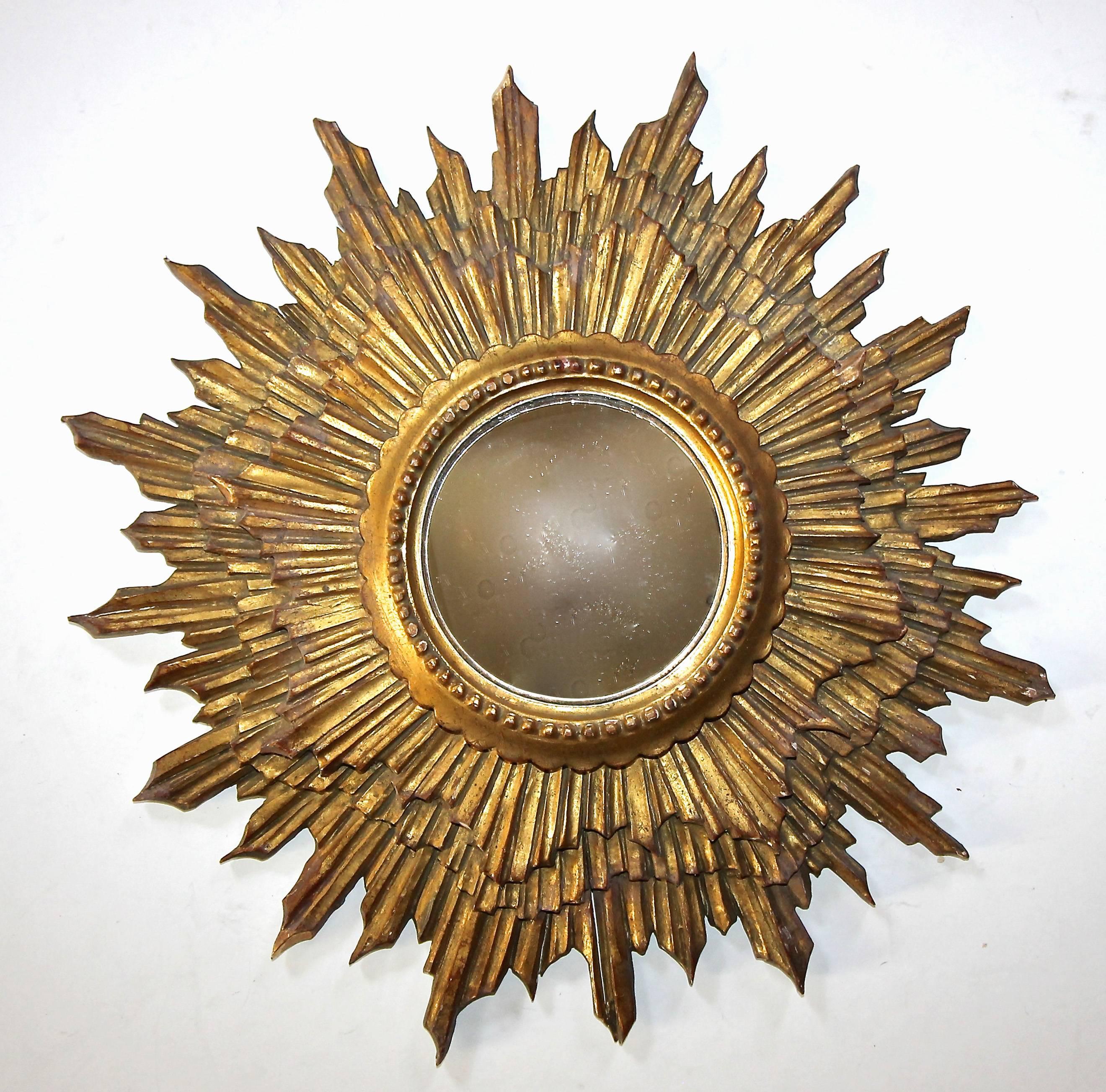 Italian made 1940s sunburst or starburst hand-carved giltwood wall mirror with inset convex mirror. Diameter of mirror 5.25".

This item is located in our Dallas showroom.