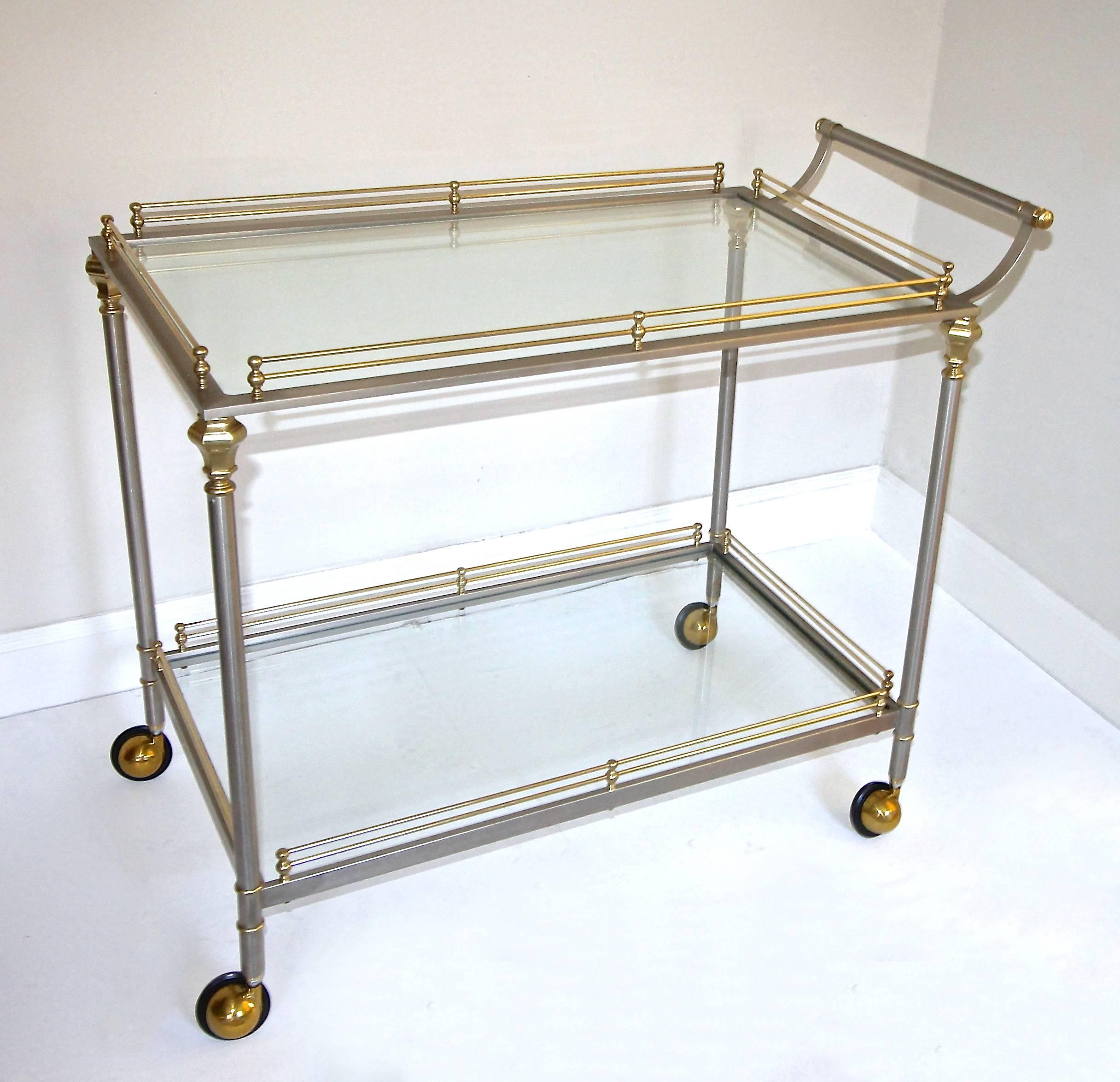 A well crafted larger scale solid brass and brushed steel Italian bar or tea cart, with two-tier glass shelves, gallery rail and caster wheels. 

Measures: Height to top shelf 29", height to top of handle 31".