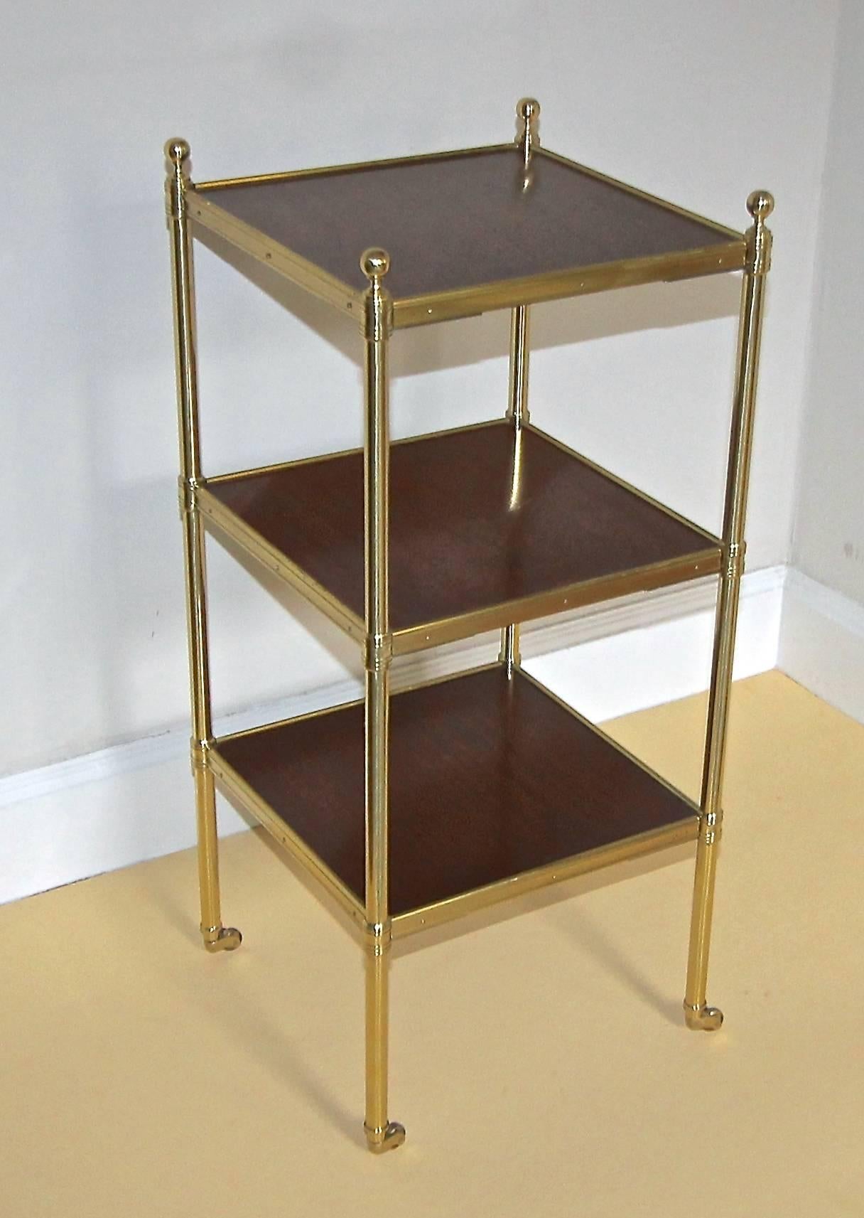 Regency style three-tier side étagère table with mahogany wood tops, brass fittings and brass caster wheels.