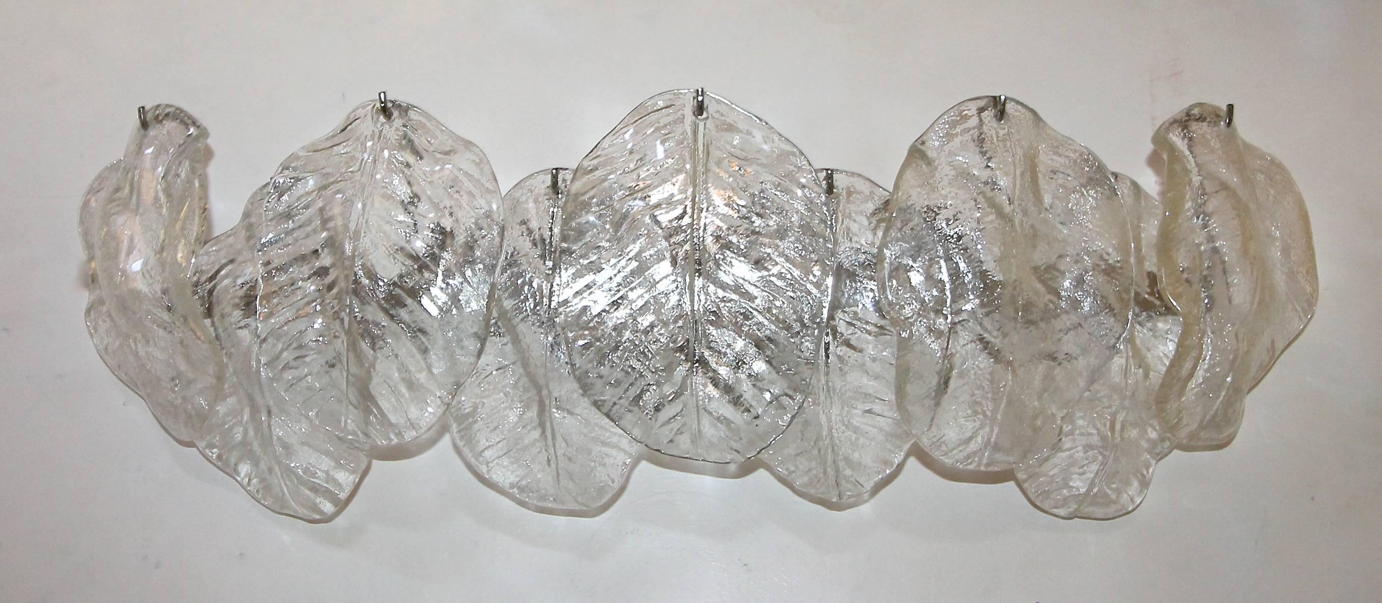 Pair of elongated Italian Murano glass wall sconces with clear textured glass leaves attributed to Mazzega. Nickel-plated steel backplates with six - candelabra B base bulbs newly wired for US. These are a harder to find style that would work well