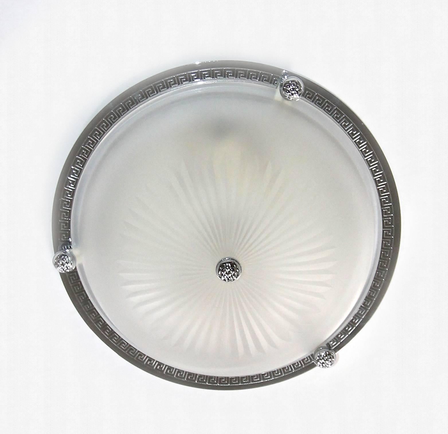 Pair Vaughan Lighting Regency style flush mount ceiling lights mounted on polished nickel black plates with Greek key border detail and cut sunburst detail to matte finish glass bowls. Each fixture uses two-40 watt max candelabra base bulbs. Price