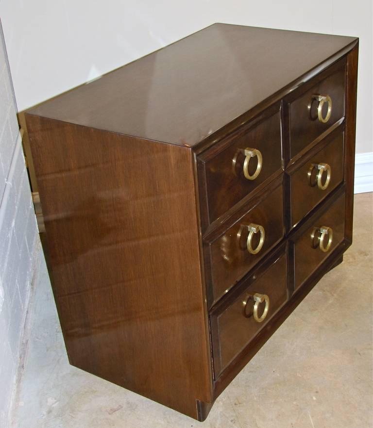 T.H. Robsjohn-Gibbings three-drawer cabinet or dresser manufactured by Widdicomb. Bleached mahogany in dark stain with original label on underside. Brass ring pulls. 