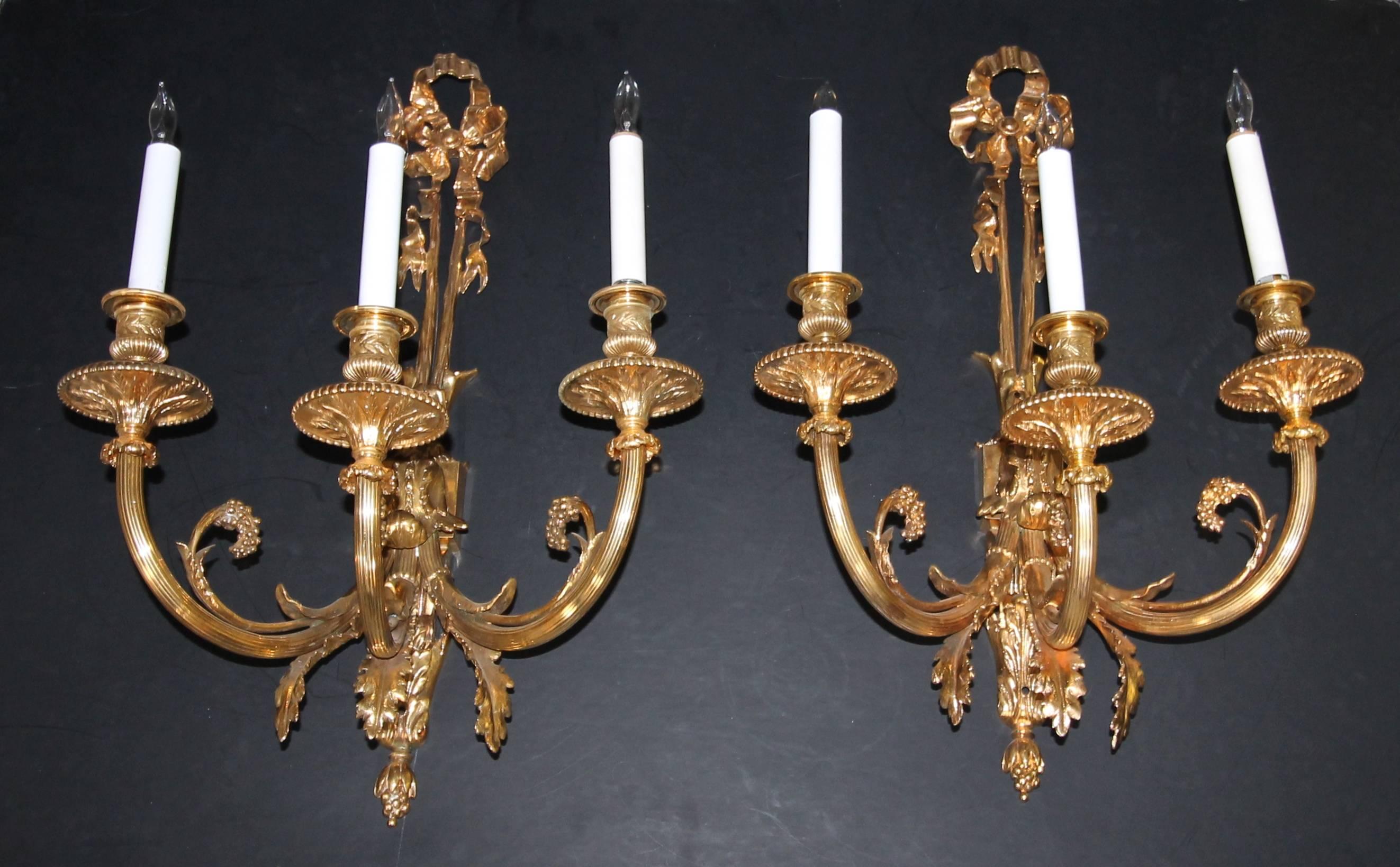 Pair of large three-light French neoclassic style bronze or brass wall sconces.