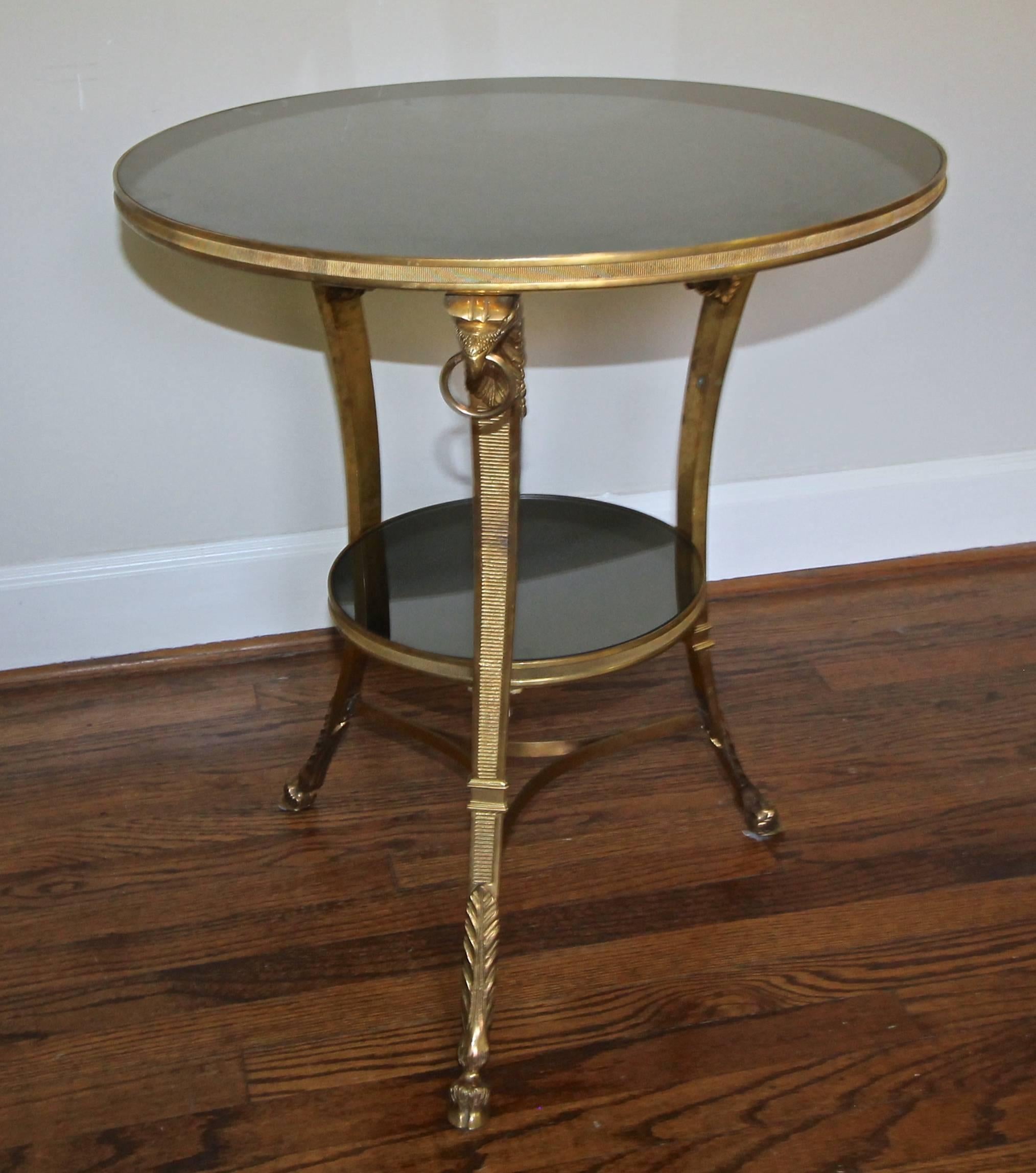 French neoclassic gilt bronze and dark mirrored glass tops gueridon side or end table, expertly crafted and detailed with eagle head and hoof feet motif.