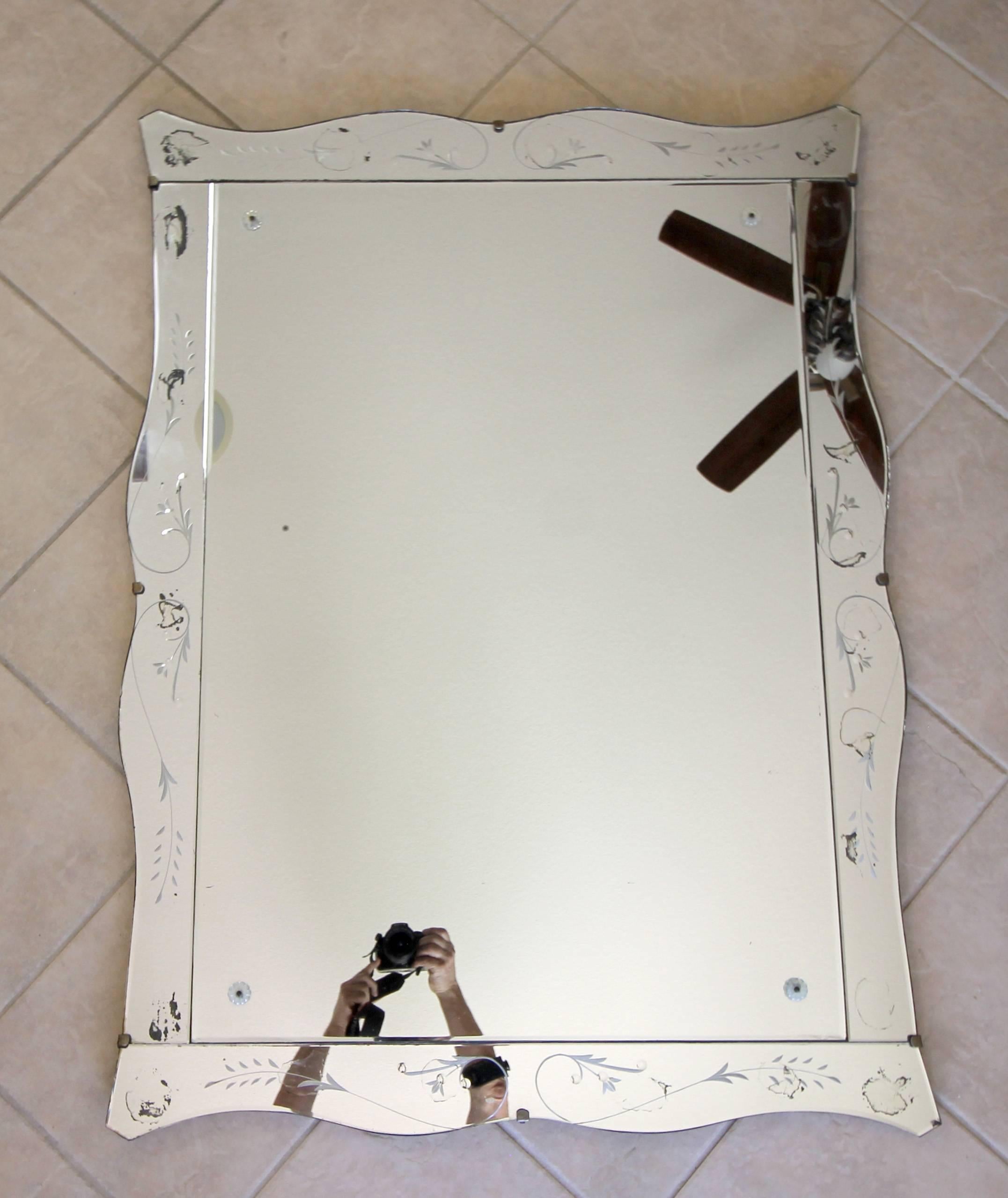 Rectangular Art Deco scalloped or wavy edge wall mirror with nicely etched mirrored panels and inset rosettes. Mirror has nice antique appearance.

 