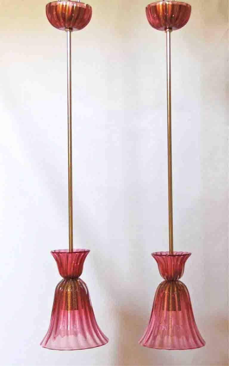 Pair of Italian hand blown glass ceiling pendants in red cranberry coloured glass with gold inclusions. Matching glass ceiling caps, suspended on brass rod. Signed "Archimede Seguso Murano".