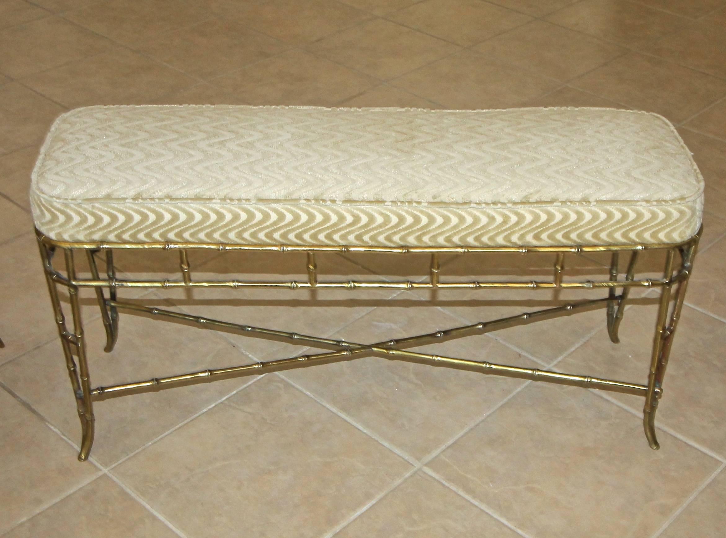 French Bagues style faux brass bamboo upholstered bench. Solid heavy construction with X-stretcher support. Newly upholstered in cream swirl pattern cut velvet fabric.