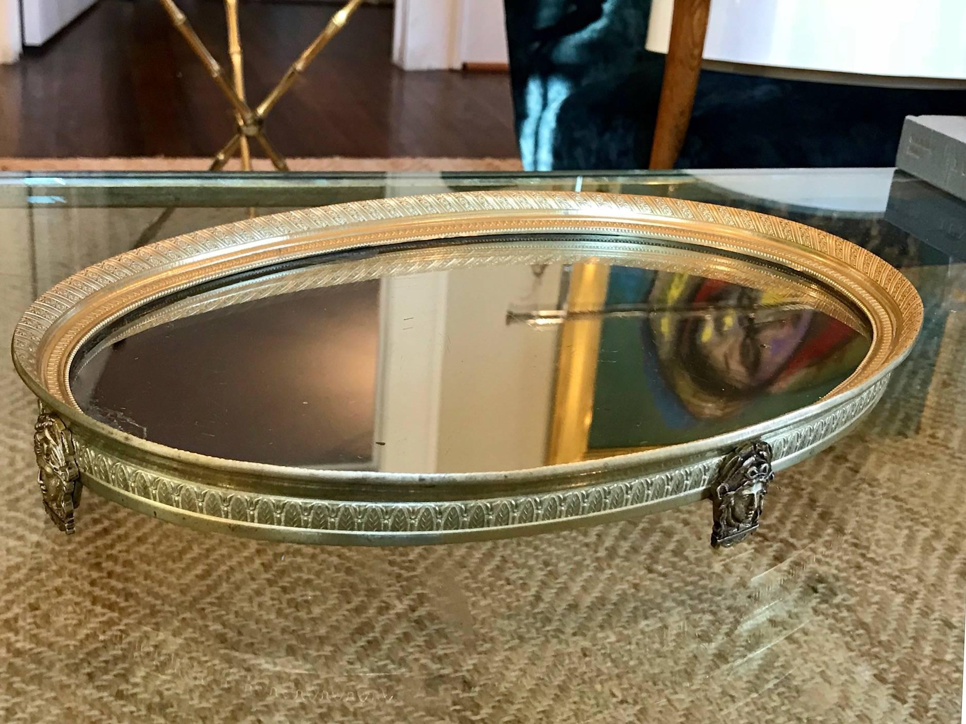 Beautifully detailed French Empire style plateau mirror or mirrored vanity tray. Interior of tray features rows of bead, acanthus and star motif patterns and acanthus motif to exterior, all being very crisp in detail. Four neoclassic faces in the