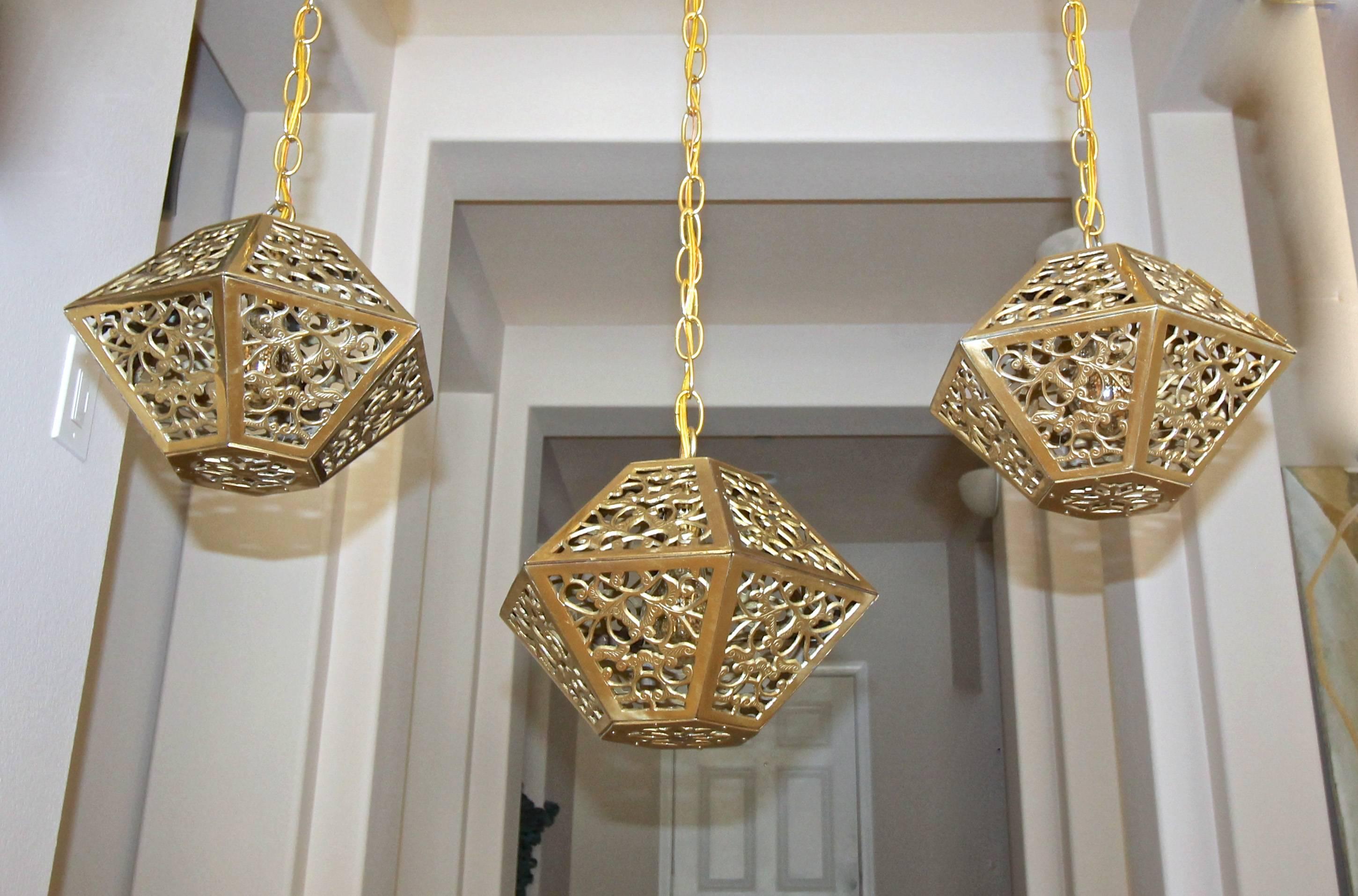 Trio (3) of high quality Asian hexagon shaped pierced brass ceiling pendant lights. This fixture creates a playful pattern on walls and ceilings when lit. Newly wired with new hardware including socket, chain and ceiling cap. Each uses single