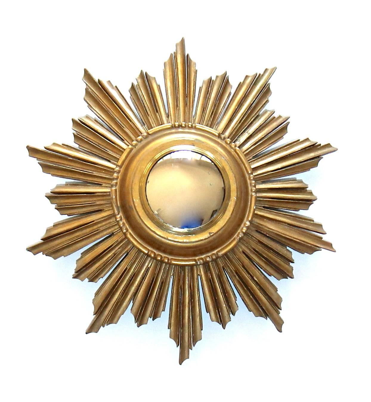 French made 1940s sunburst or starburst carved giltwood wall mirror with inset convex mirror. Diameter of mirror 3.5