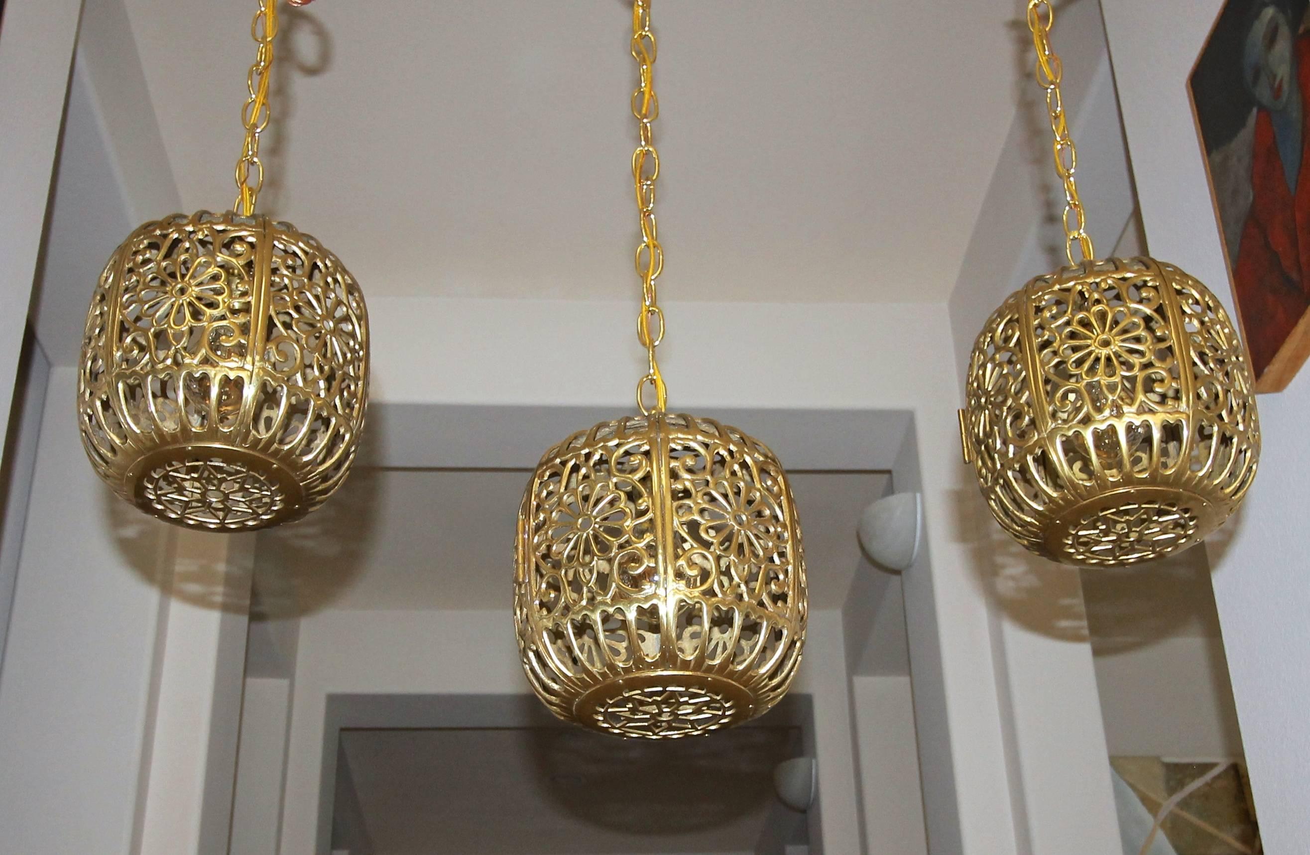 Trio (3) of high quality Asian pierced brass pendant ceiling lights. This fixture creates a playful pattern on walls and ceilings when lit. Newly wired with new hardware including socket, chain and ceiling cap. Each uses single regular A-base bulb.