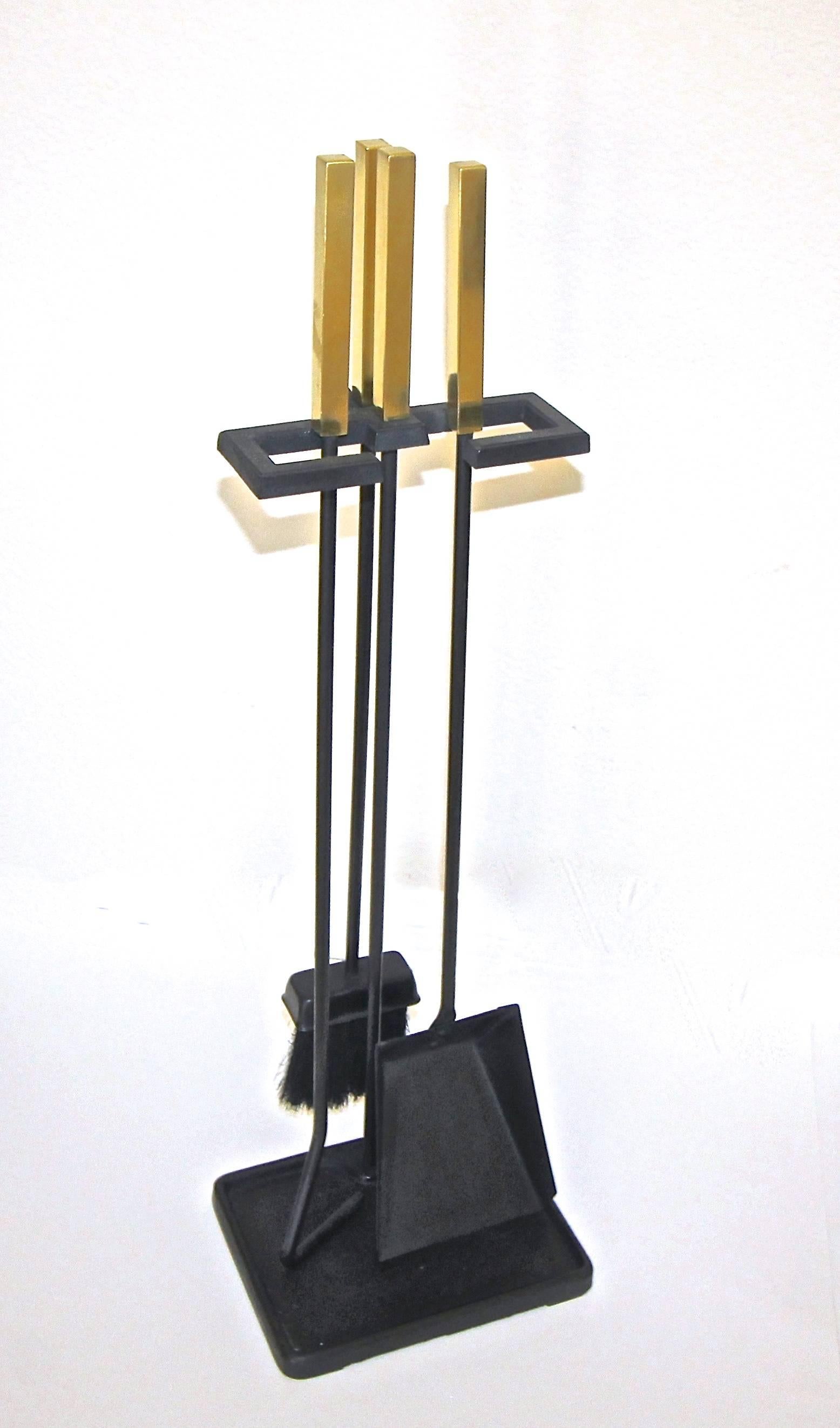 A handsome set of mid century black cast iron fireplace tools set, with square solid brass modernist style handles. 