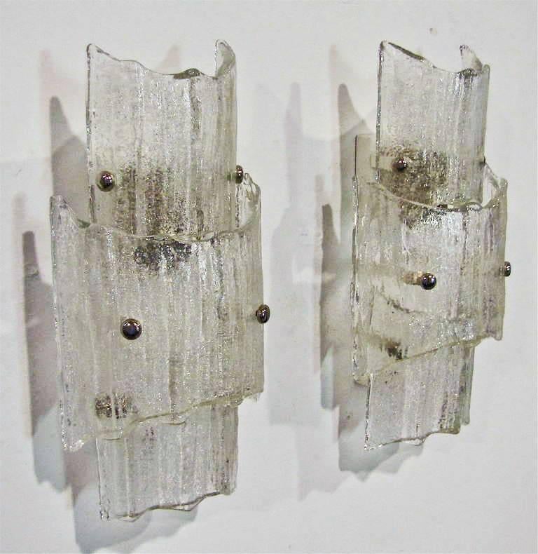 Pair of Kalmar clear and textered three-panel wall sconces with nickel-plated brass fittings and matte white backplates. Each sconce uses one max 