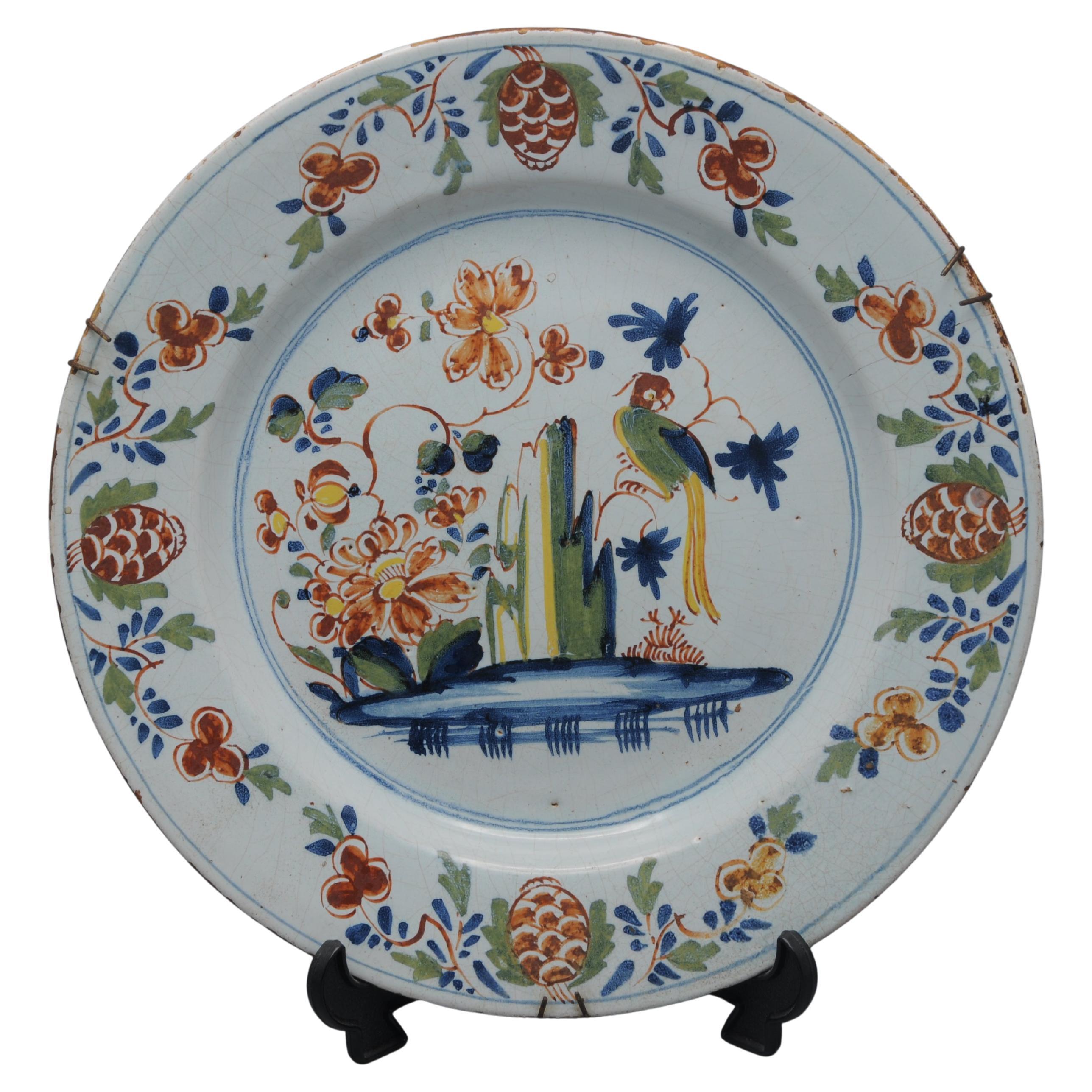 Motif bien-aimé du Delft anglais, la Perruche sur une branche dans un paysage de rochers et de fleurs. Ce motif particulier a été attribué à la poterie de Lambeth High Street d'Abigail Griffith. circa 1765-75. Peint en couleurs polychromes de jaune,