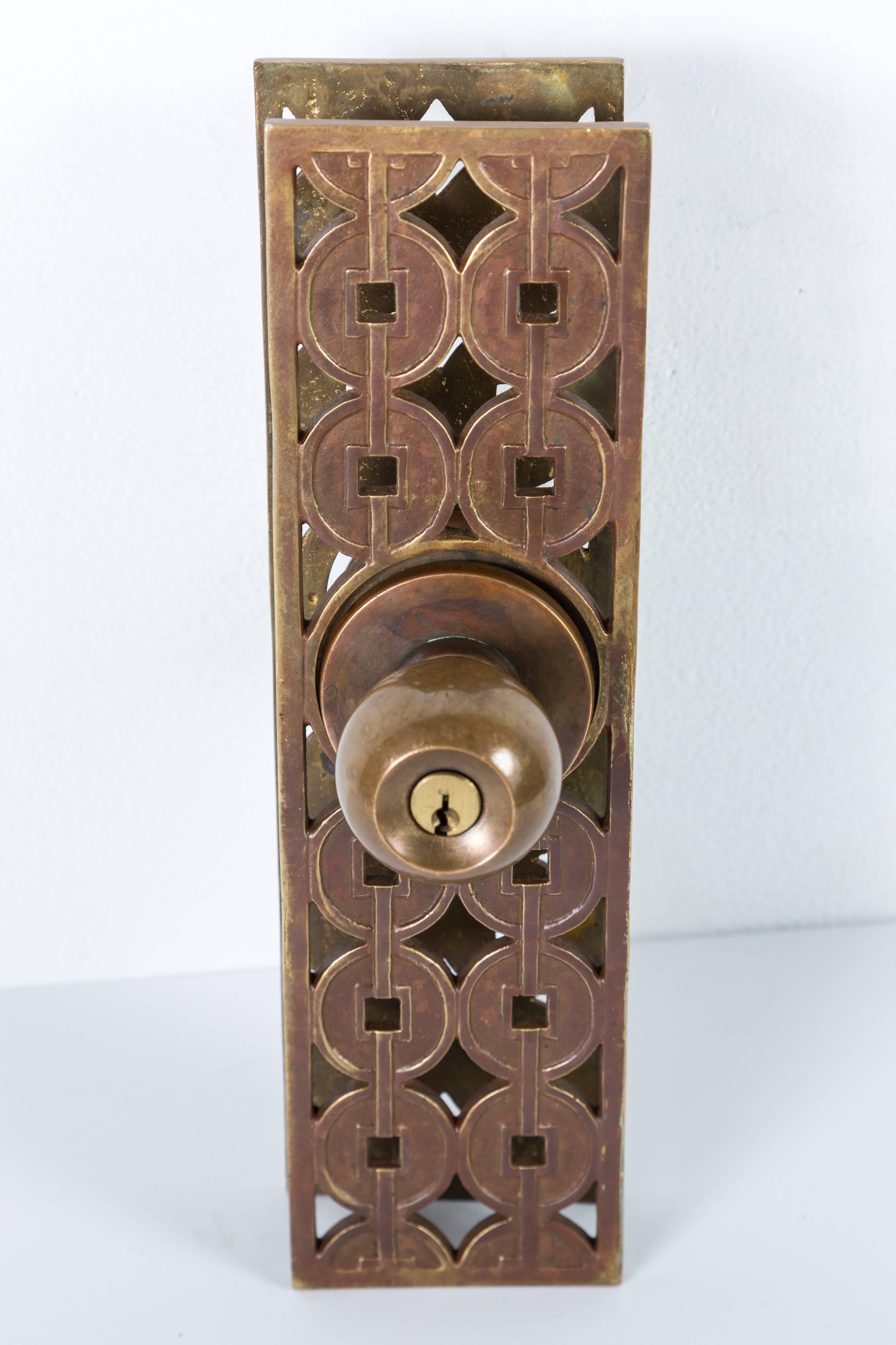 Mid-Century Schlage entry set with key. Set includes two knobs, two plates, a lock with a 2 3/8