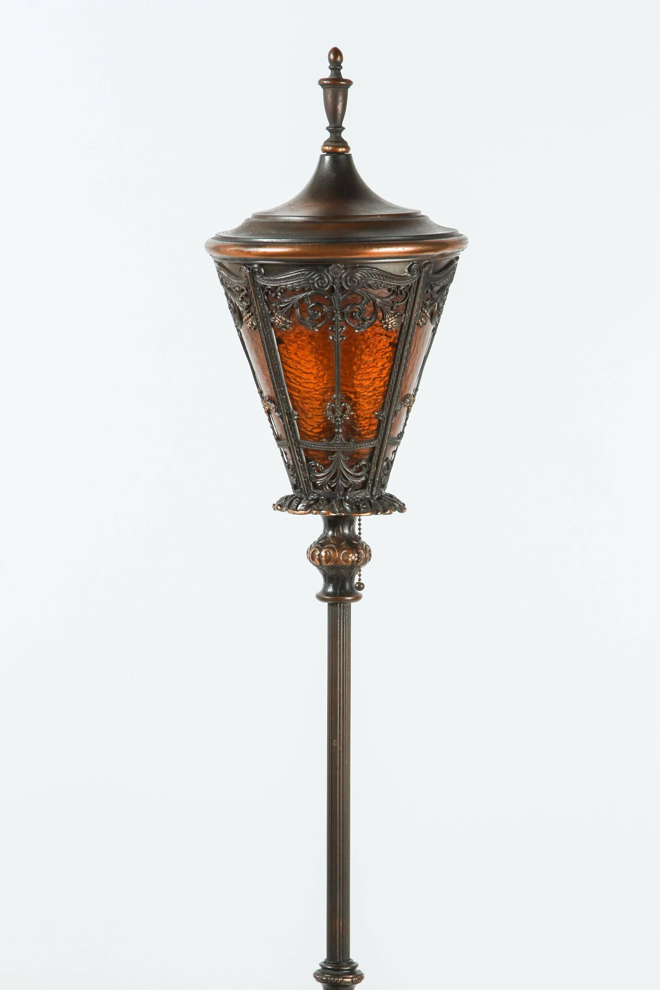 Pair of American cast iron and brass floor lamps with amber glass.