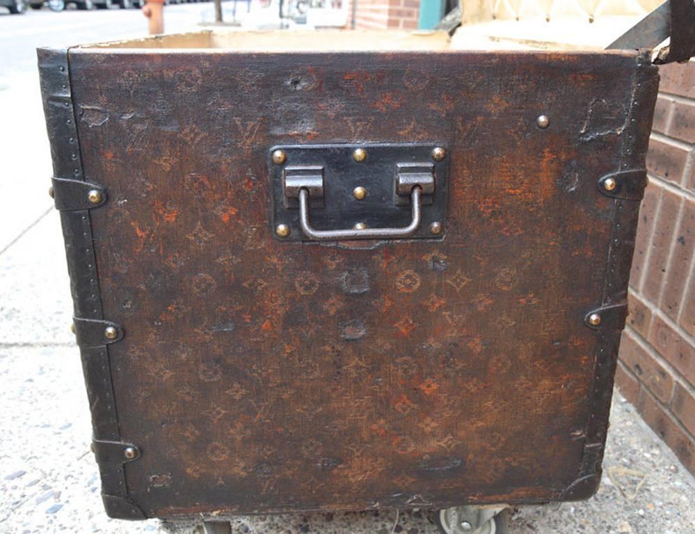 AUTHENTIC LOUIS VUITTON monogram canvas steamer trunk c1910 in good antique condition.  Signature monogram canvas exterior trimmed with bronze hardware, wood panelling, and metal rivets. Triple latch closure opens to a beige canvas lined interior