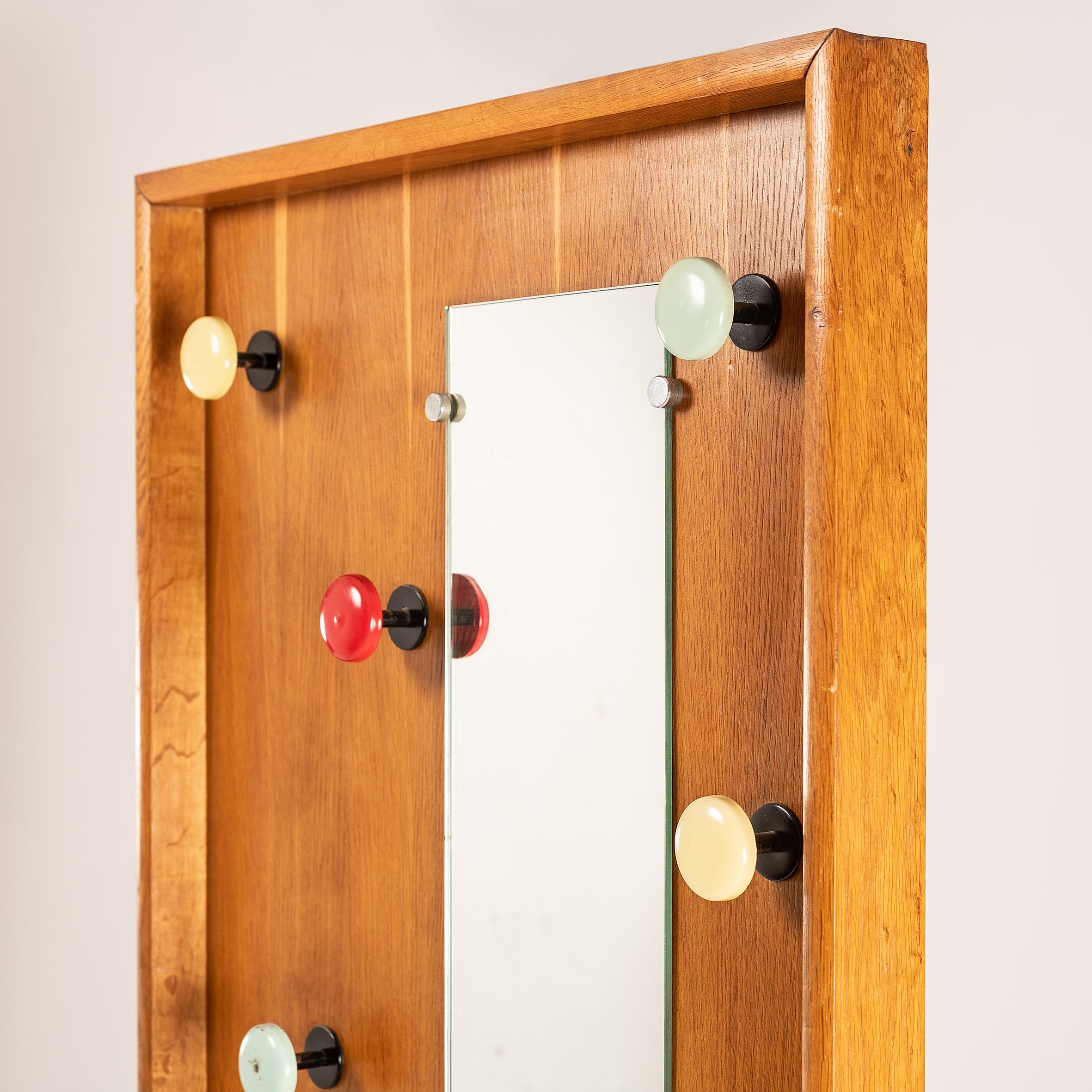 Straordinario appendiabiti e ombrelli da parete francese della metà del secolo scorso, realizzato in ferro battuto e legno di Oak, attribuito allo stile di Roger Feraud, circa 1950. Questo pezzo di grandi dimensioni è caratterizzato da una struttura
