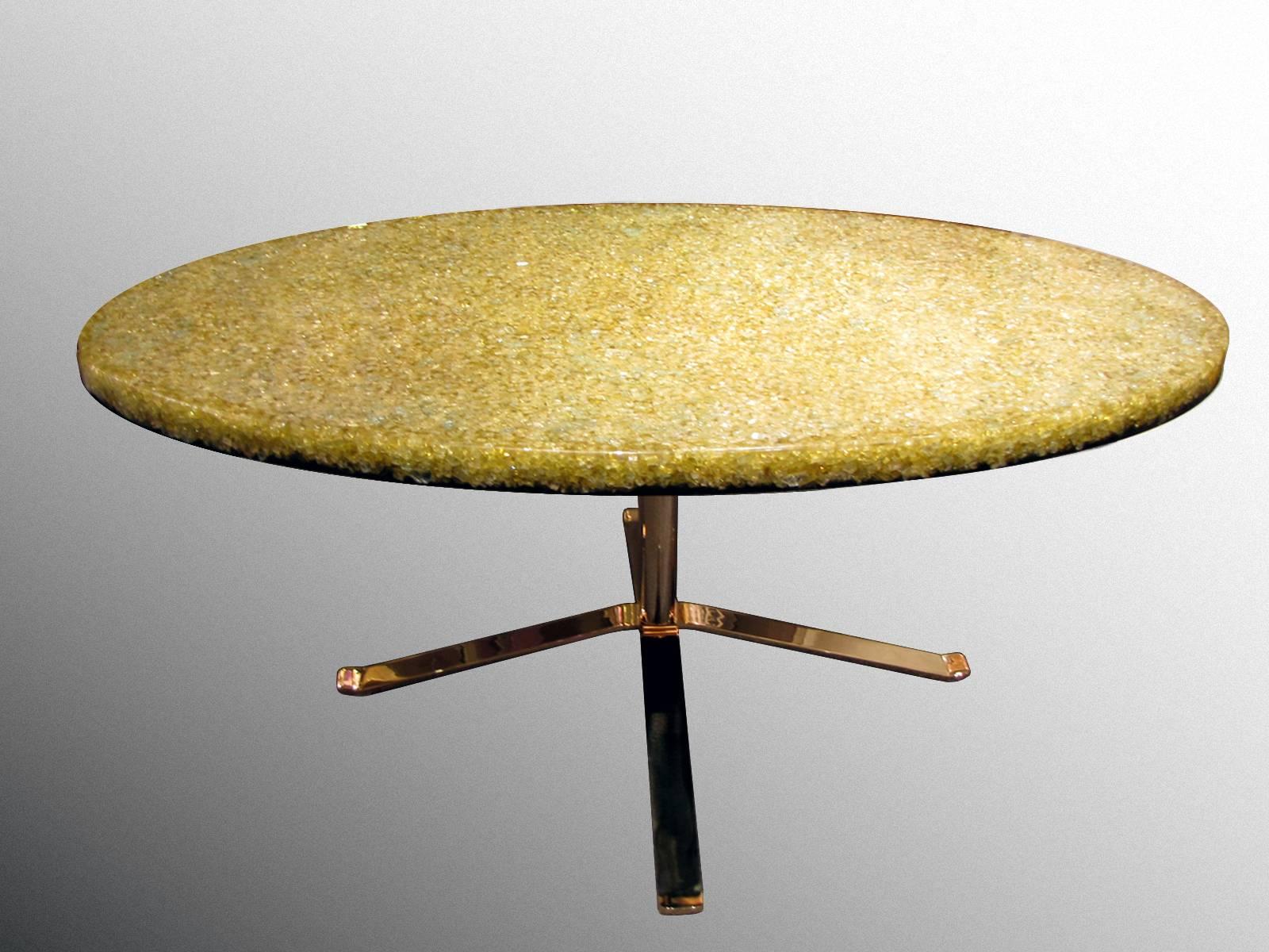 Coffee table with an oval resin top, circa 1970, by Pierre Giraudon (1923-2012).
Top in yellow translucent resin with many glass inclusions. The underside of the tray is in black resin. Four crossed legs in gilded stainless steel base.