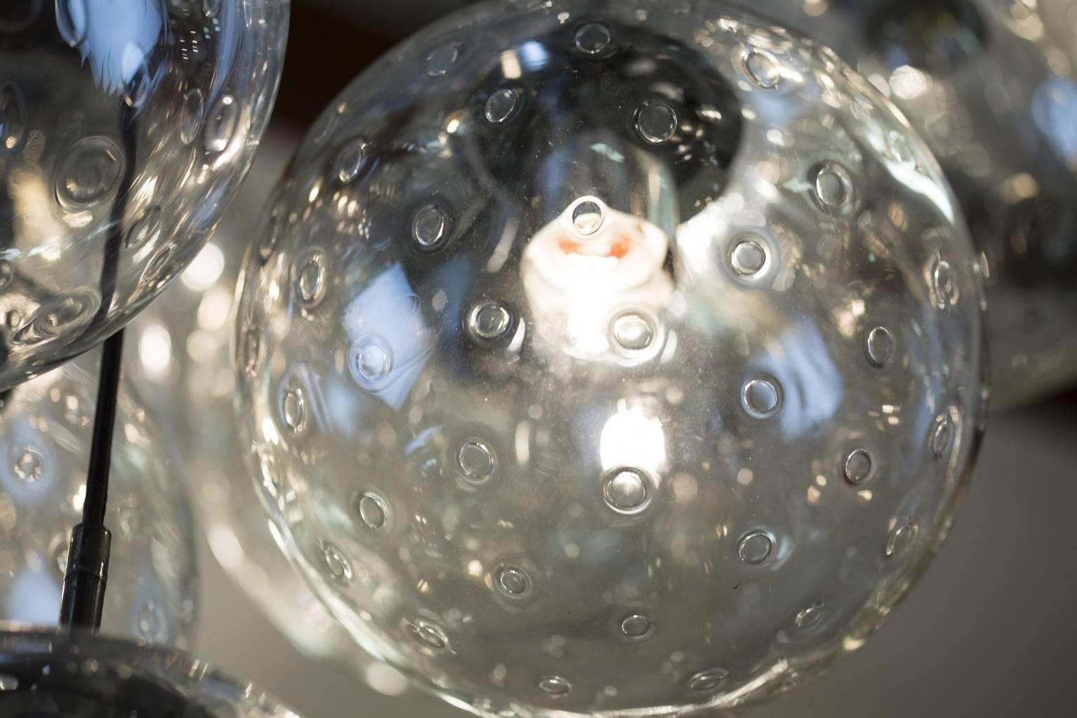 Très grand et impressionnant lustre à boules de verre RAAK.
20 boules en verre faites à la main avec des ampoules à air.
Le diamètre du lustre est de 45,28 pouces.
Le diamètre de chaque boule de verre est de 13,8 pouces.
La hauteur totale réelle
