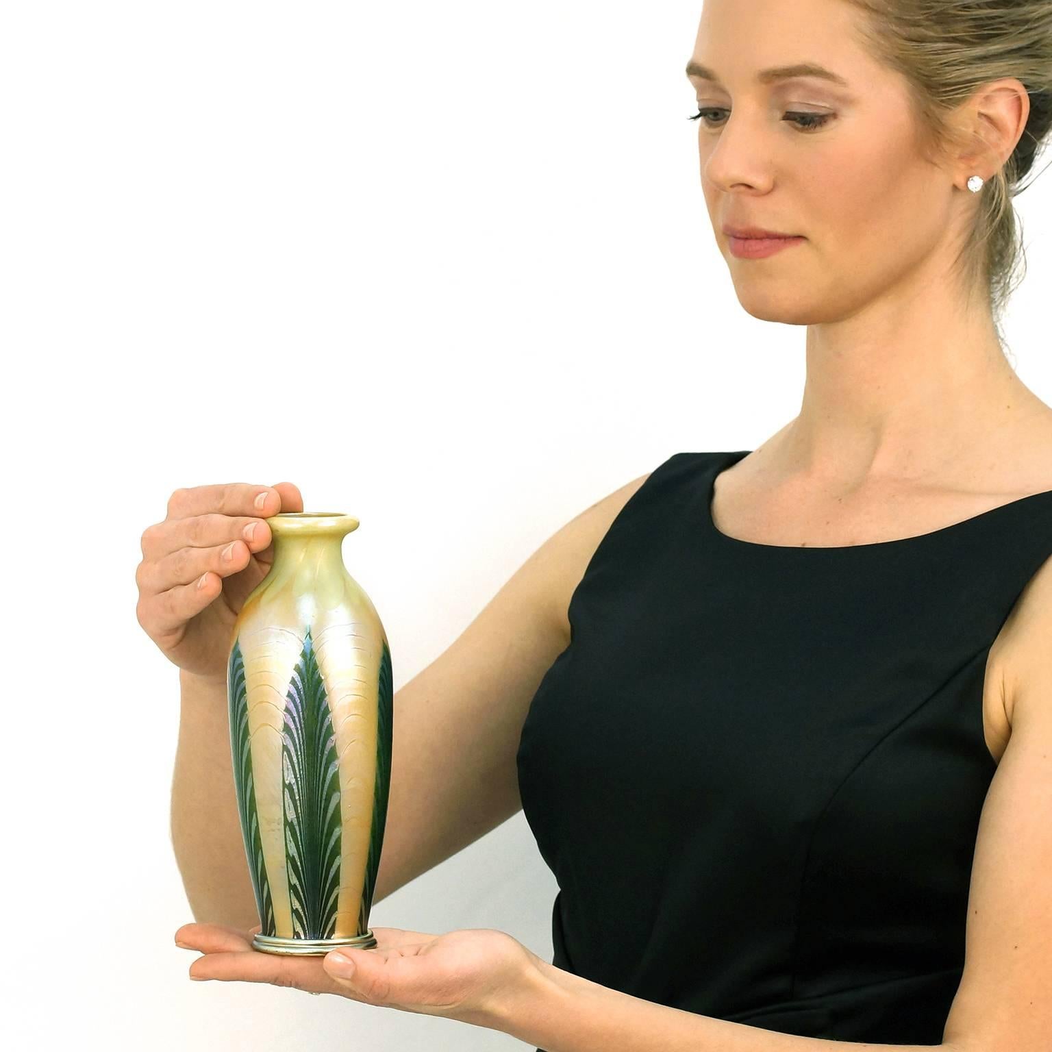 Circa 1910, Louis Comfort Tiffany, Tiffany Studios, New York.  This rare Louis Comfort Tiffany vase features gold Favril and aventurine green glass in a pulled feather design with a gold aurene foot.  Its pleasing form and stunning color combination