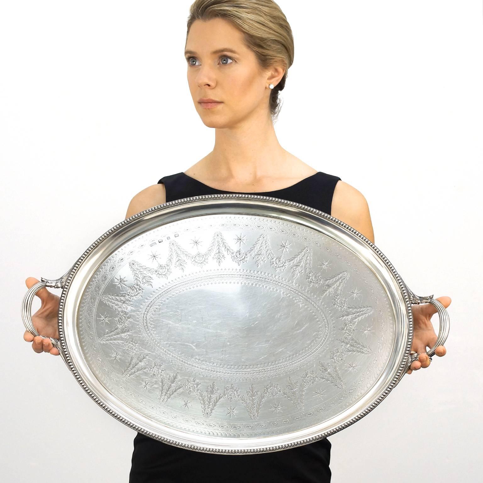 Circa 1876, sterling, by Elkington & Co. Ltd., Birmingham, England. This elegant tray by the renowned silversmithy Elkington & Co. is adorned with gorgeous hand-engraving. Its swagged pattern, delineated by stars, is framed with a bold, beaded edge.