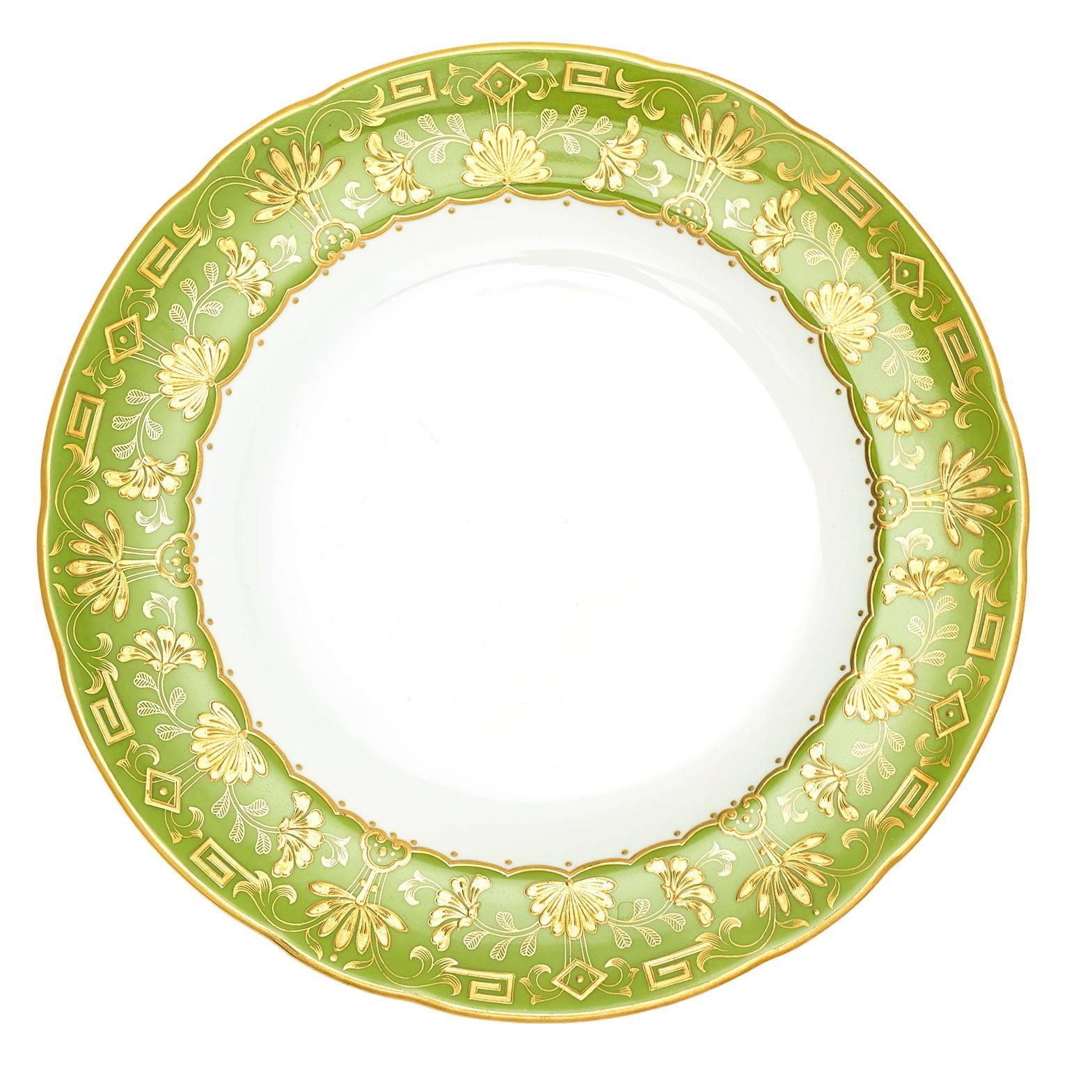 Minton, England, circa 1890s. 12 plates. Caught somewhere between the Japonaise aesthetic and the Arts and Crafts movement, these beautiful Victorian-era plates feature bright spring-green borders enhanced by superb raised gold detail. Floral and