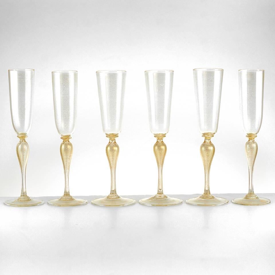 Circa 1980s, Martinuzzi, Italy. These beautiful champagne flutes are hand-blown in traditional Venetian gold-flecked glass. Especially appropriate, the pattern emulates the fizz and sparkle of the sparkling wines they are meant to contain.