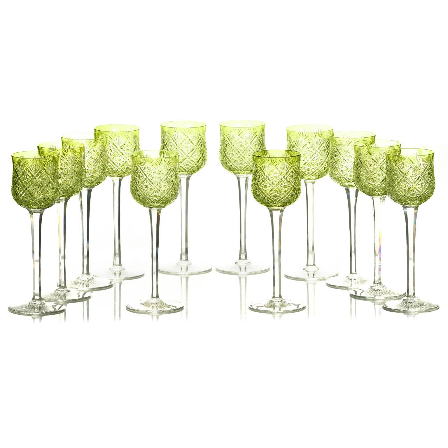 Circa 1910, France. This incredible set of 12 wine goblets by Baccarat in vivid chartreuse cut-to-clear crystal is nothing short of stunning. Colorfully decorating an impeccable table, these glasses are finely made, beautifully designed, and in